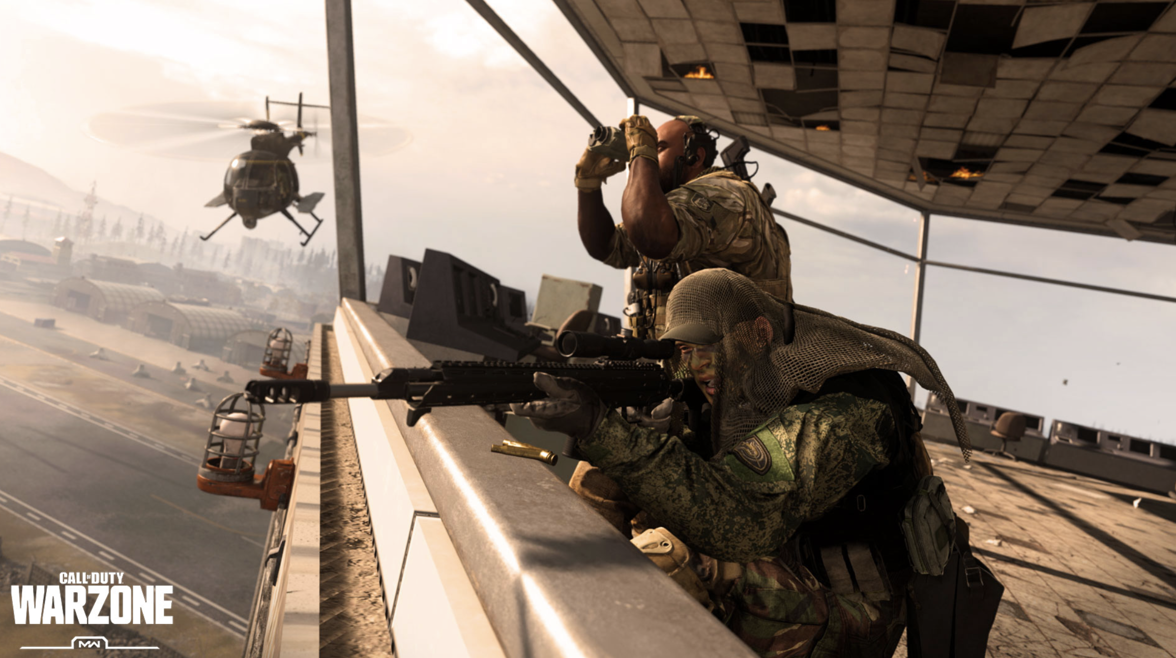 A screenshot from Call of Duty showing soldiers looking out from the roof of a building, with a helicopter flying in the background.