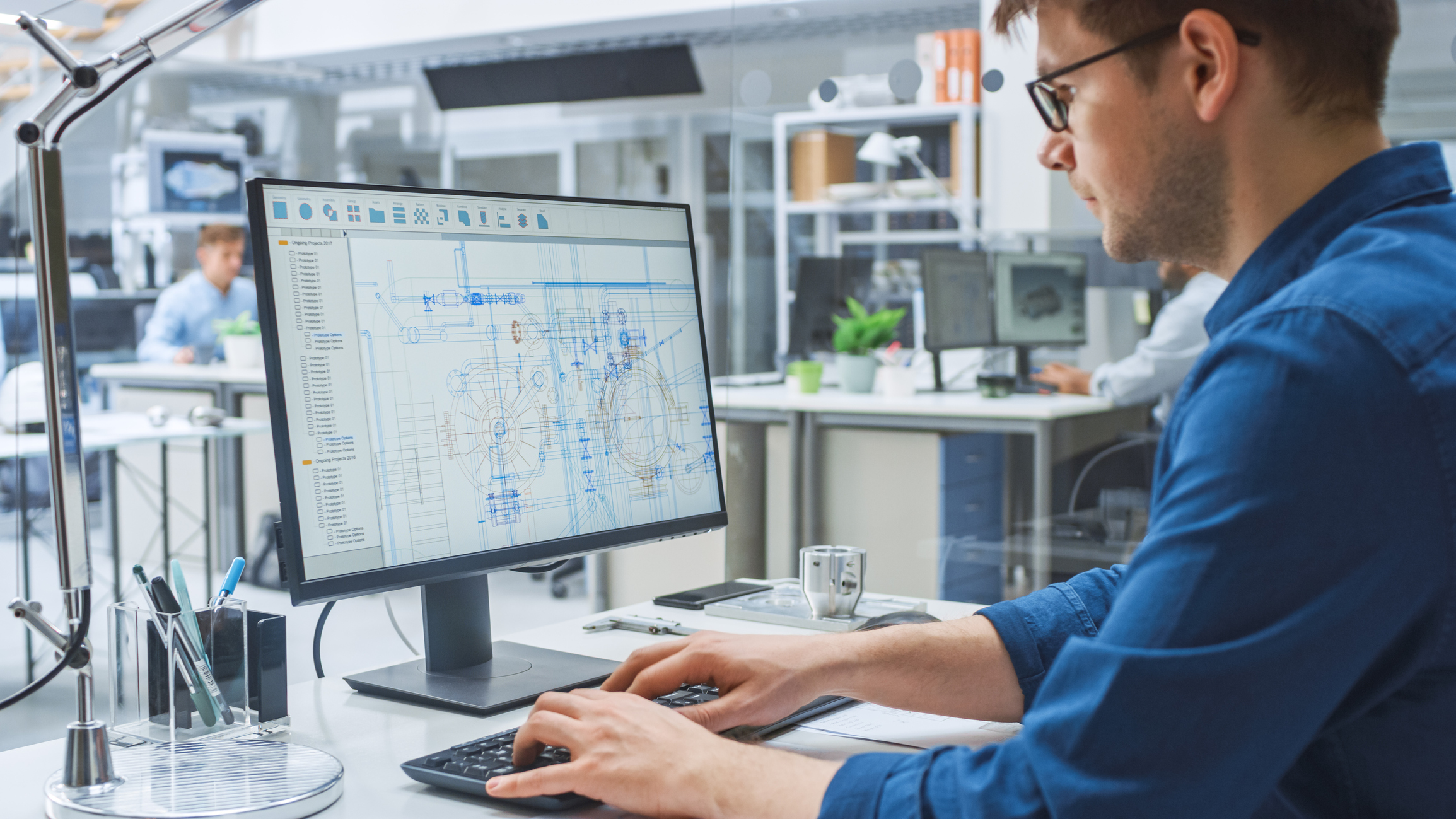 A man works with CAD software.