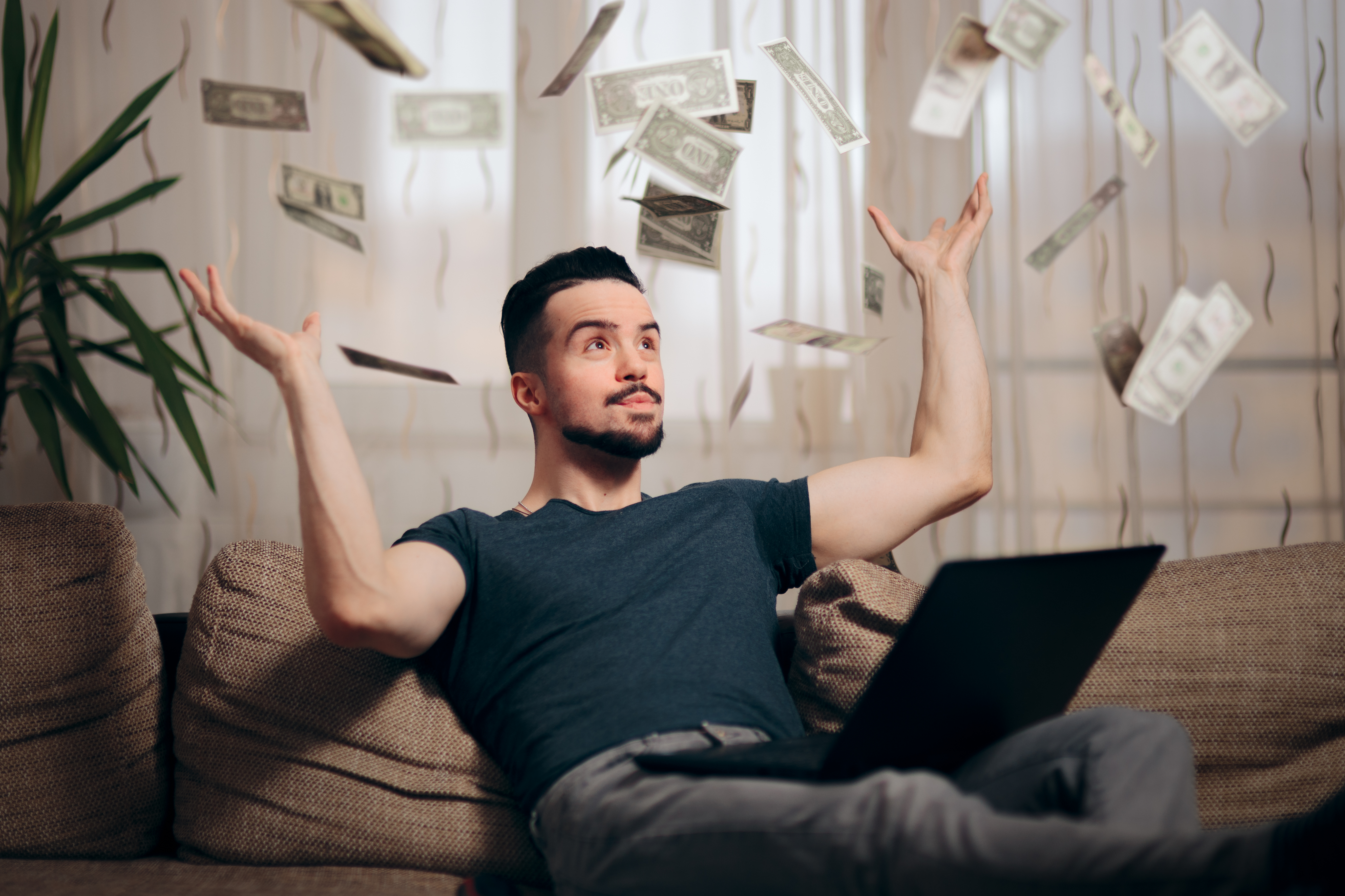 Young man throwing money into the air.