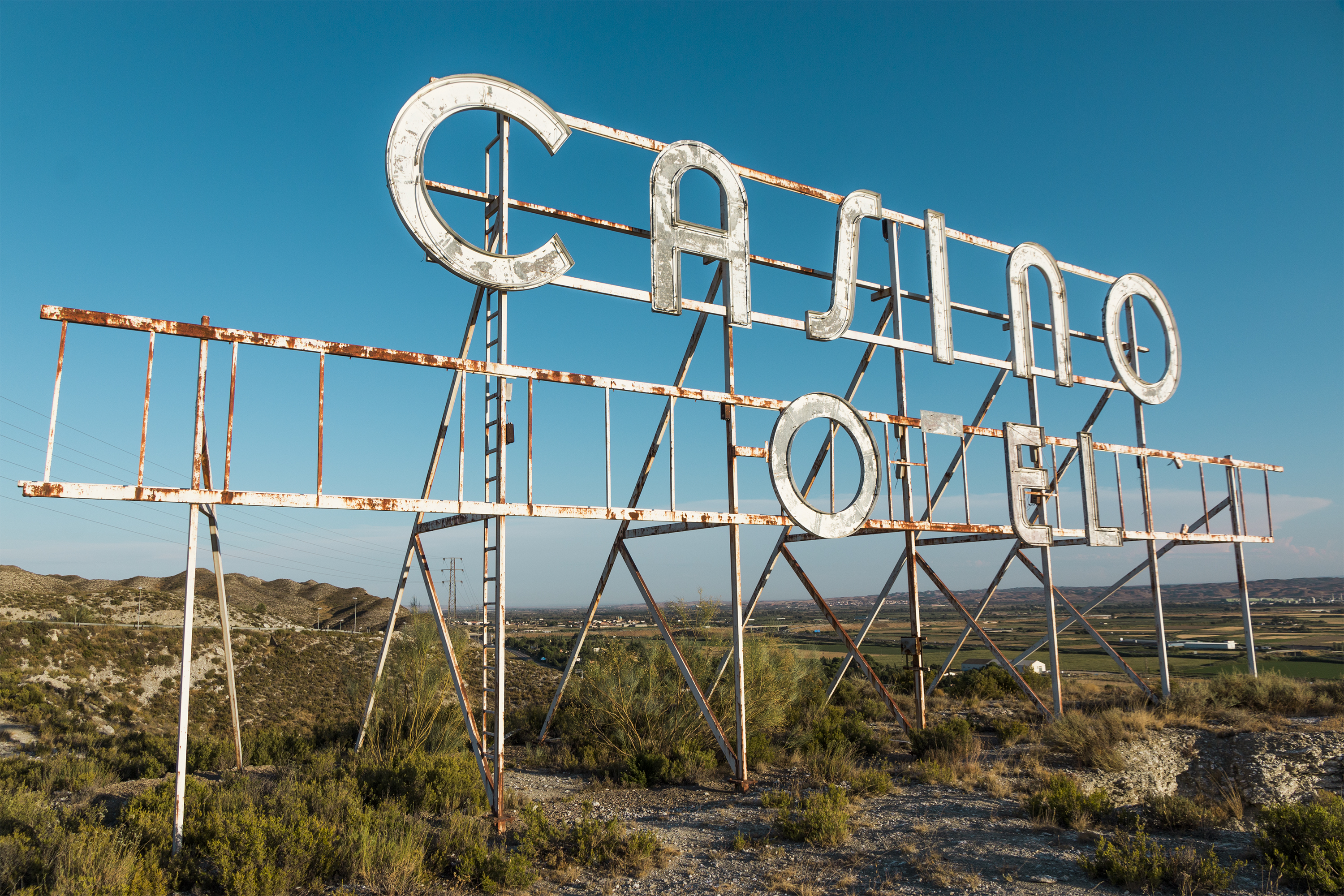 A dilapidated casino sign with an open field behind it