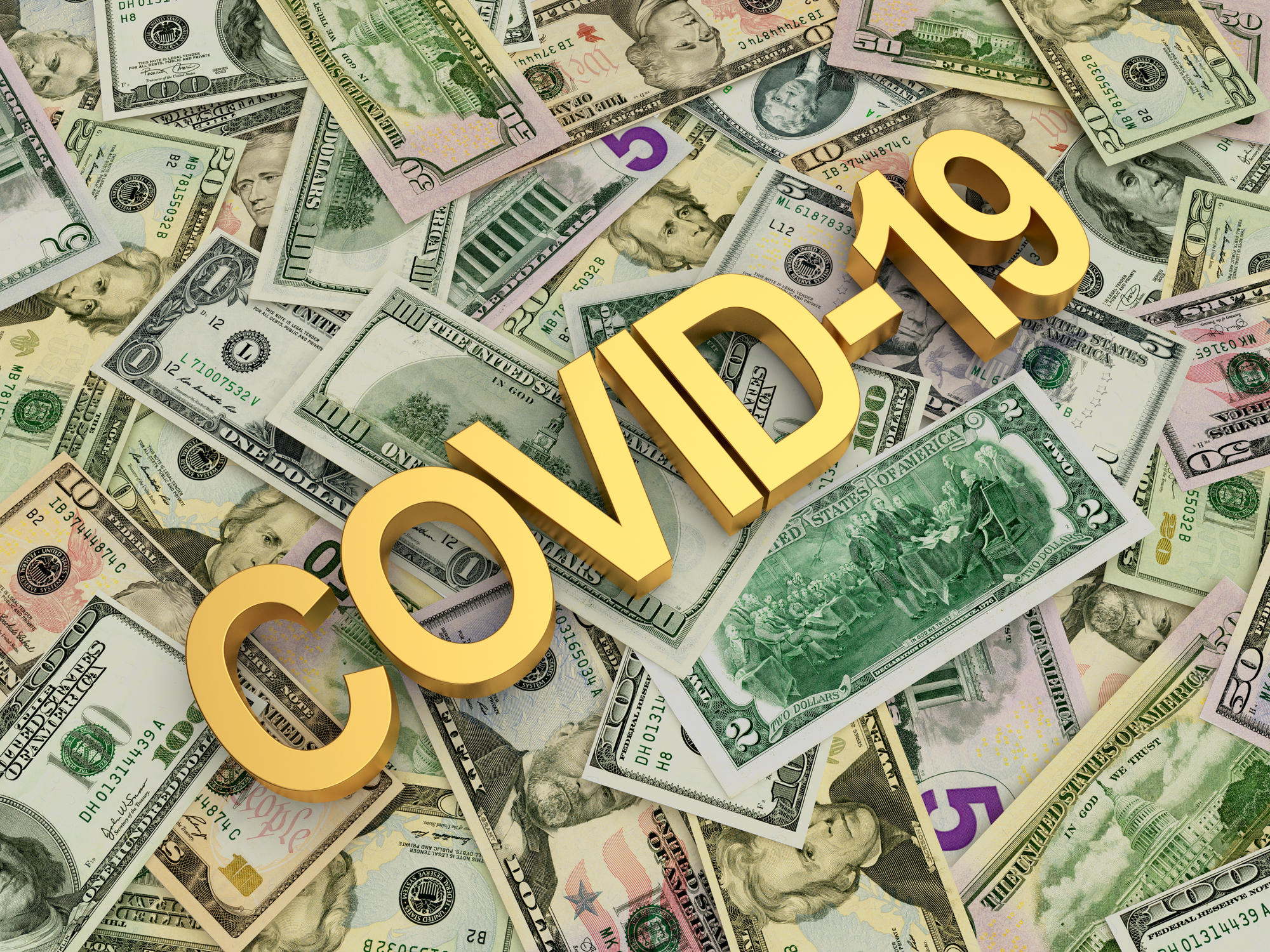 A bed of dollars has the word covid-19 atop it.
