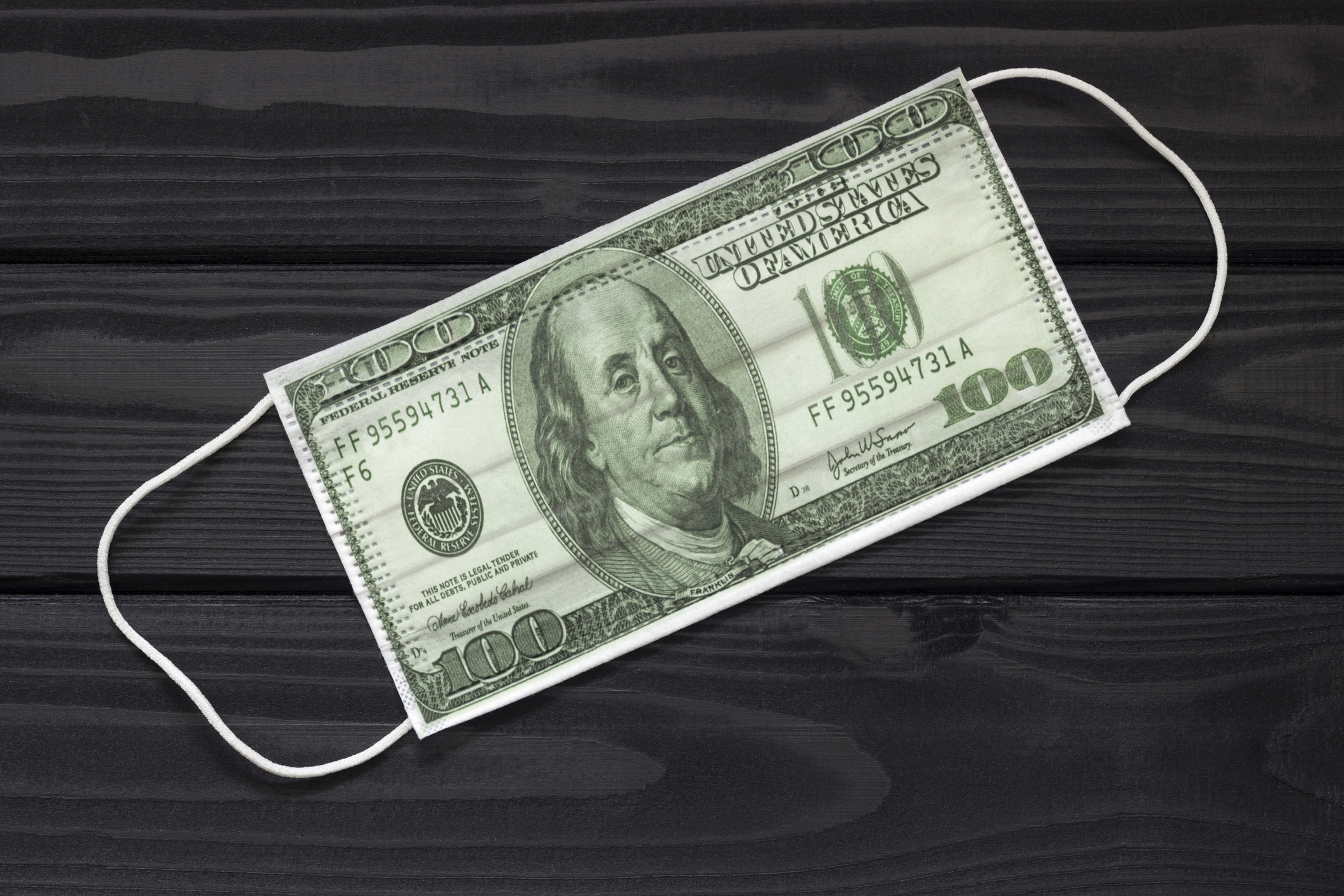 A mask made out of a hundred dollar bill is shown.