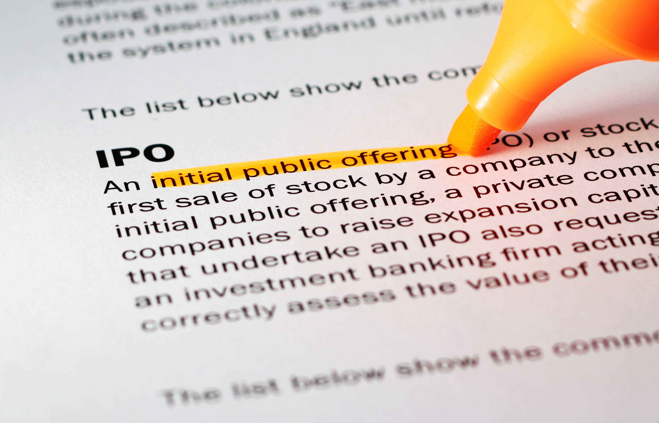 Paper with the definition of an IPO with a pen highlighting initial public offering