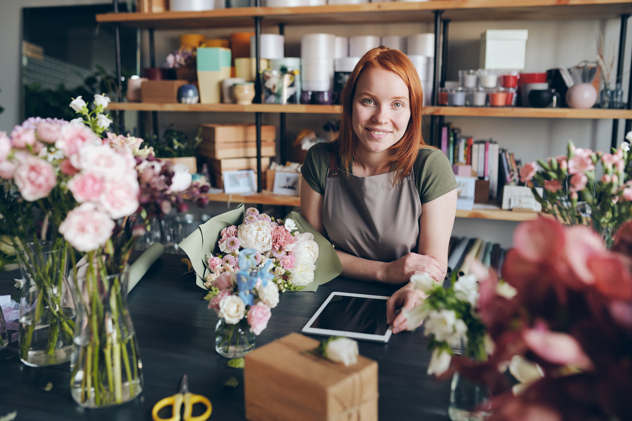 Woman at counter of flower shop_GettyImages-1170449864