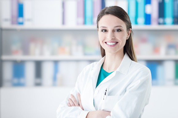 Doctor standing by pharma shelf. 
