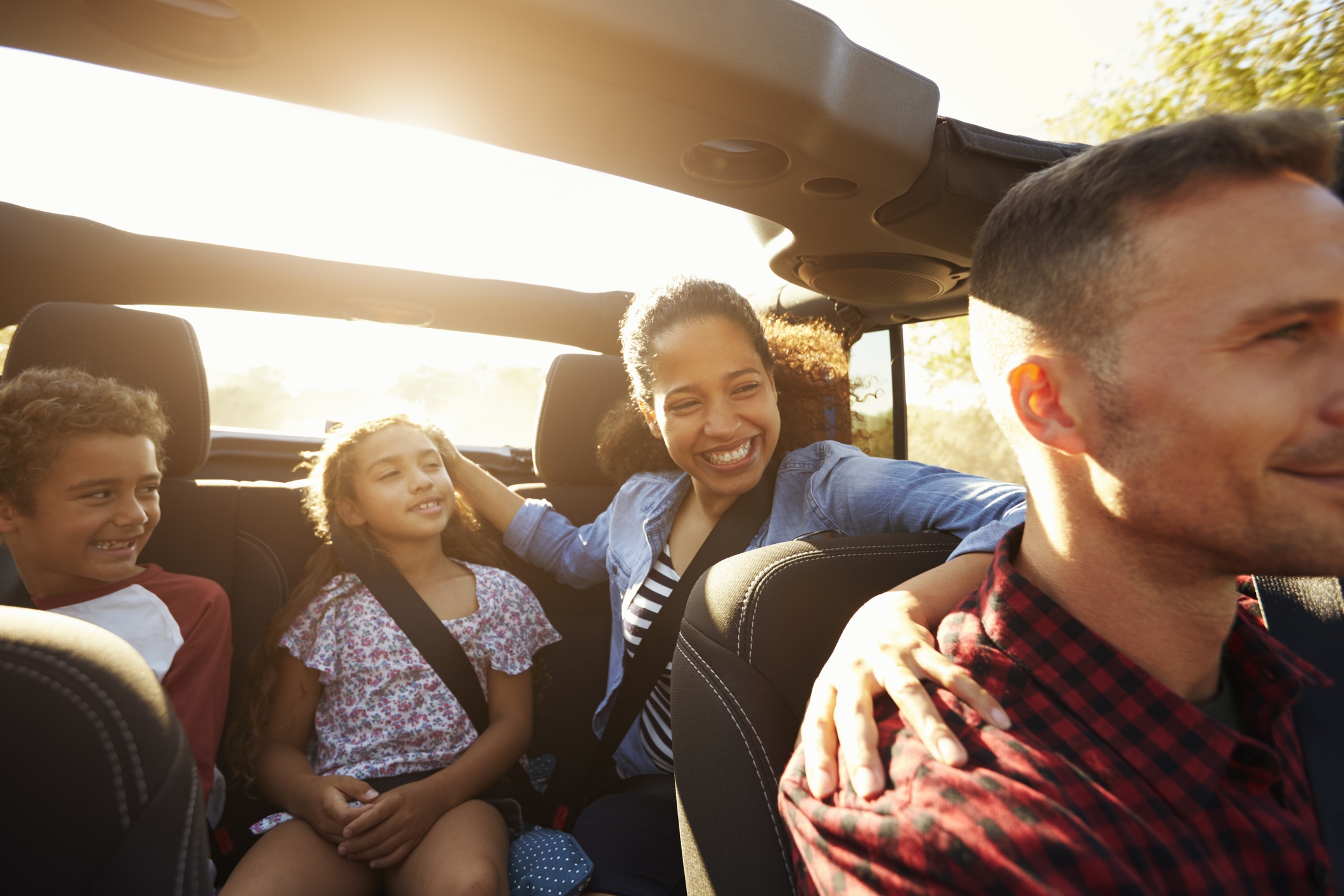 family of four in car on road trip POC