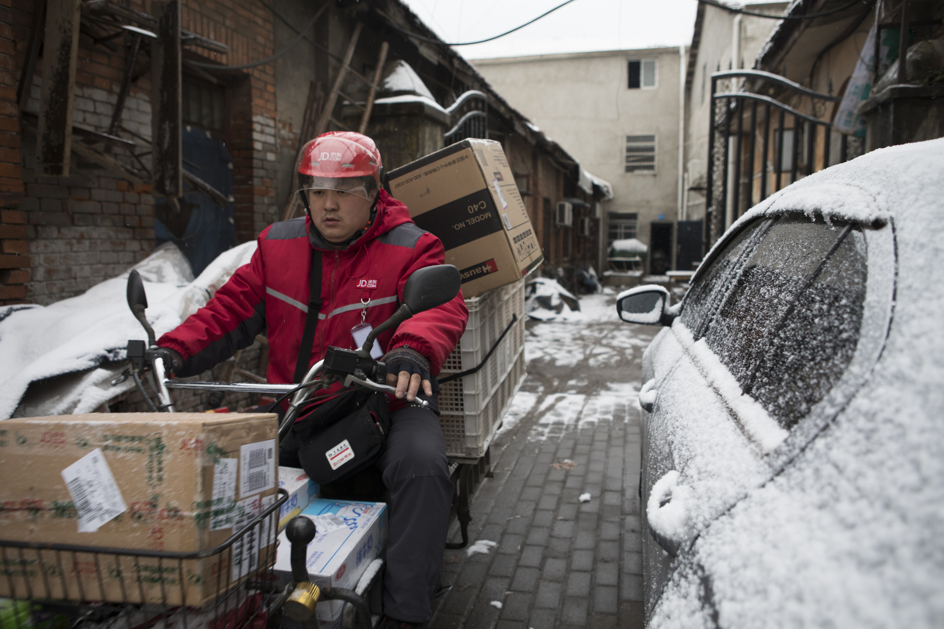 A JD.com delivery worker on a motorbike.