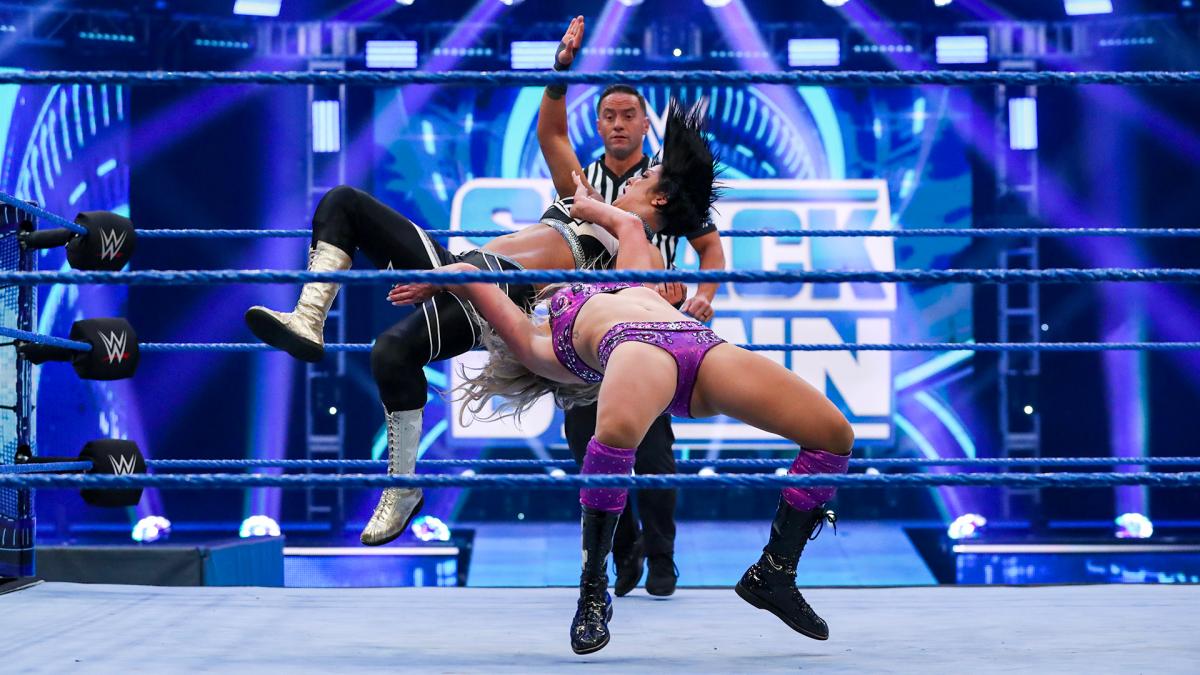 WWE wrestlers performing in the ring.