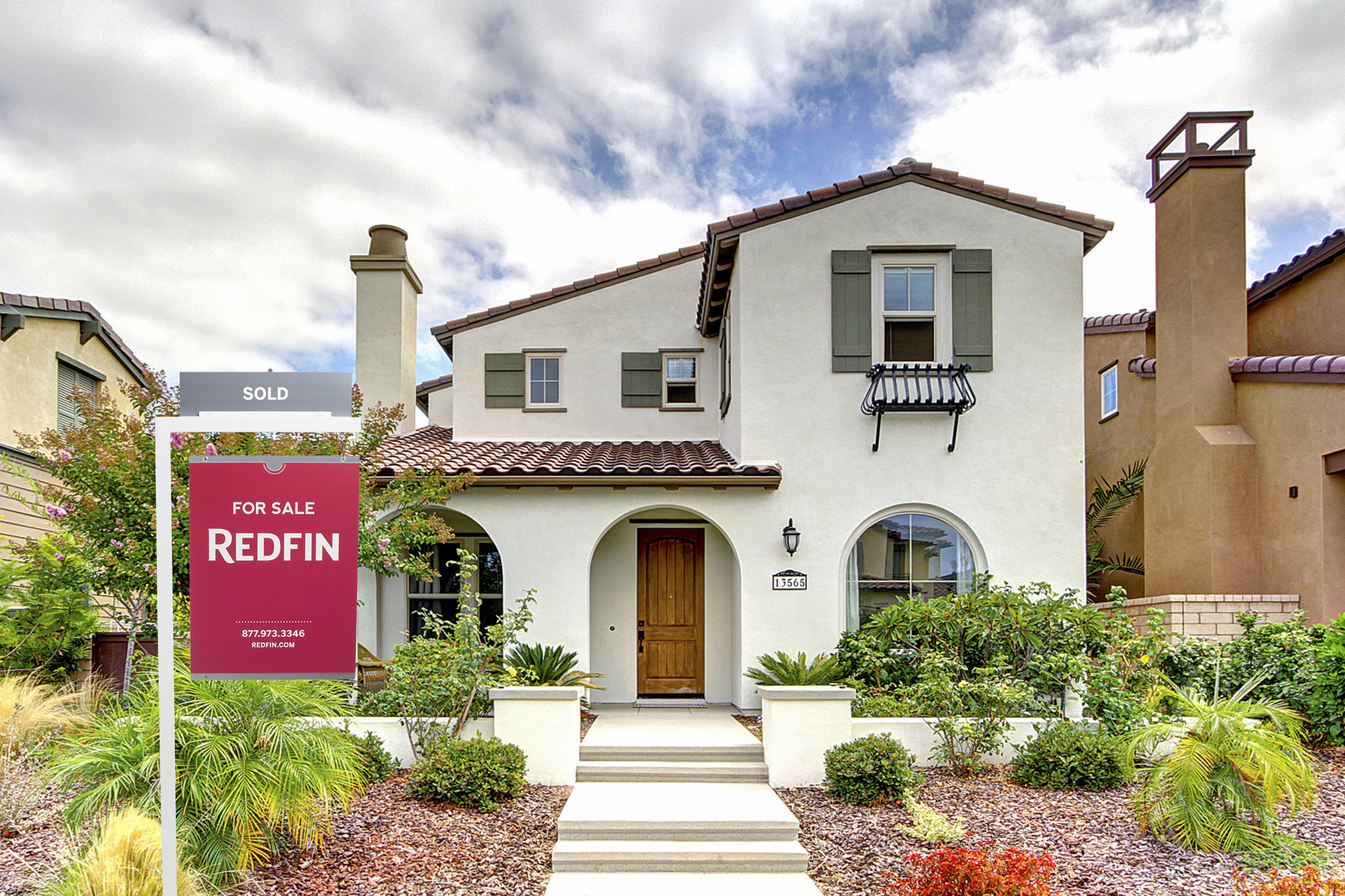 A house with a Redfin for sale sign in front of it.