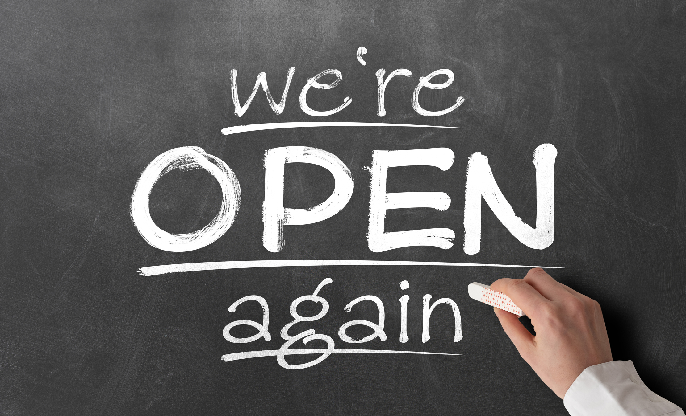 A chalk board sign that says, "We're open again."