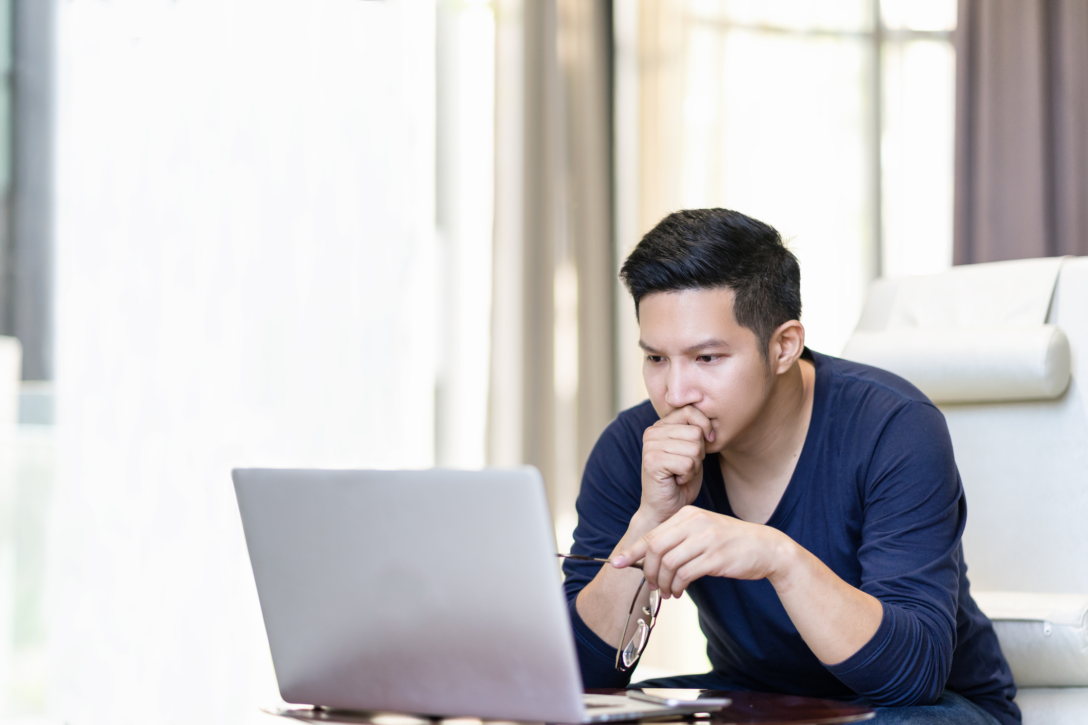 Man at laptop with serious expression
