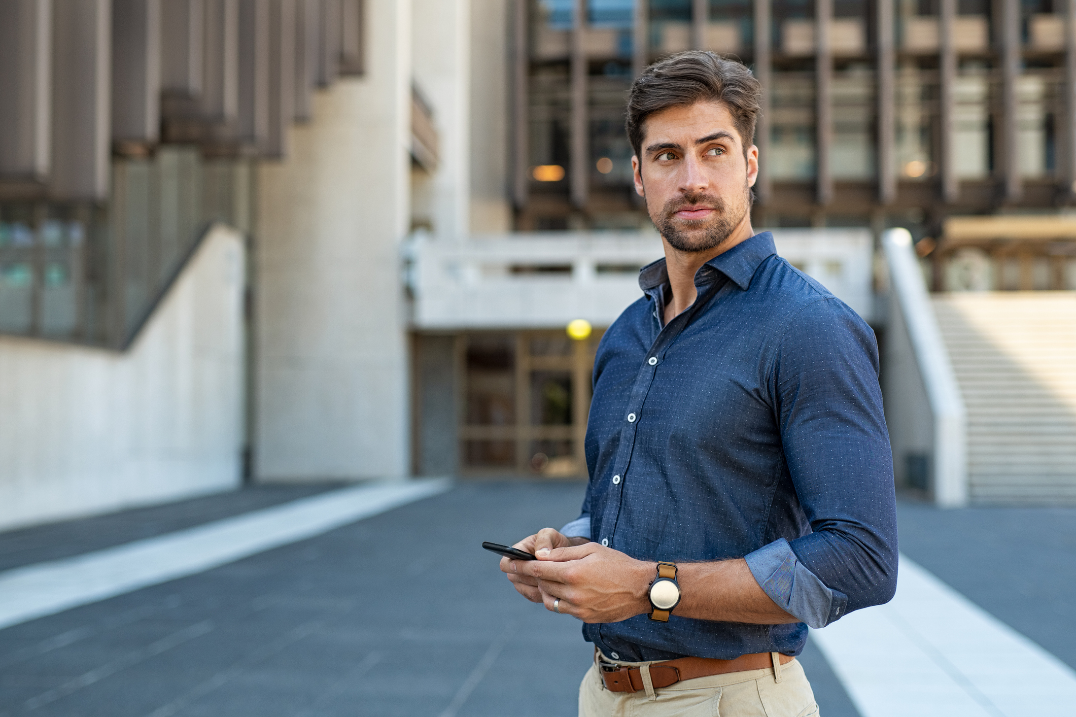 Man standing outdoors holding cell phone
