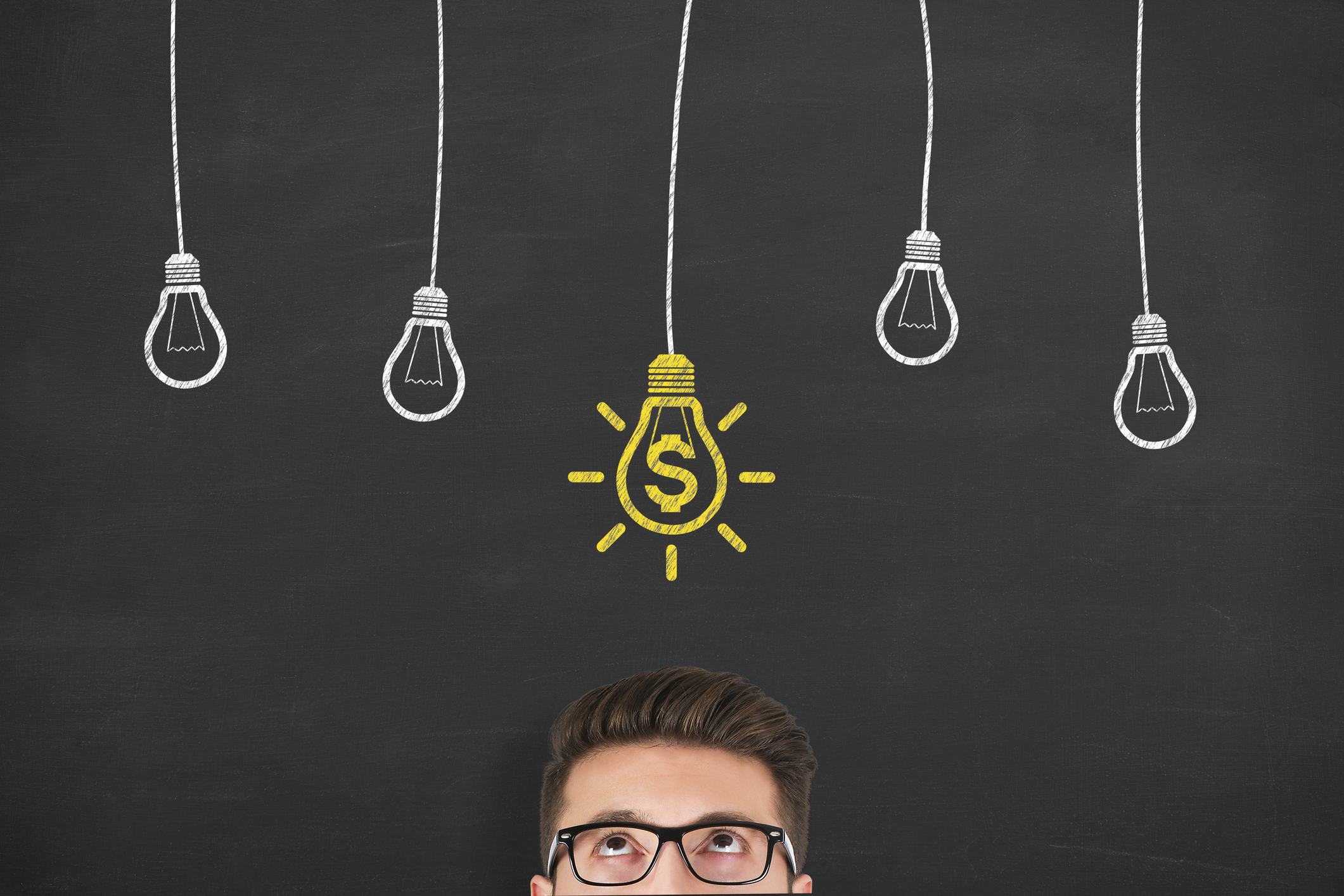 Man looking up at chalk drawing of light bulb with dollar sign