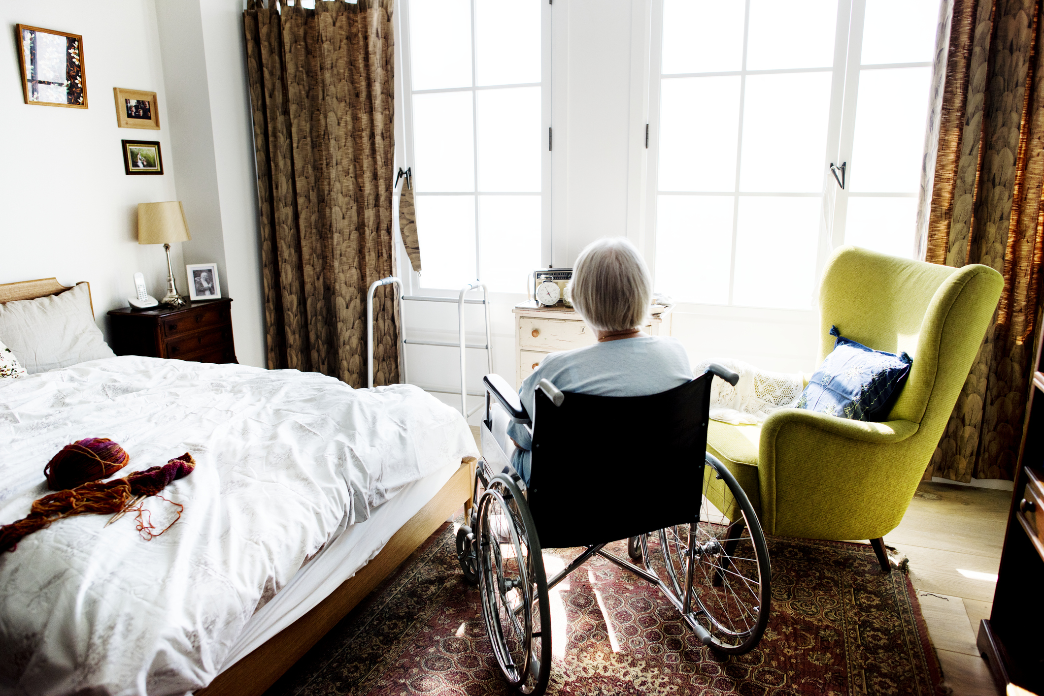 Woman in wheelchair in large bedroom