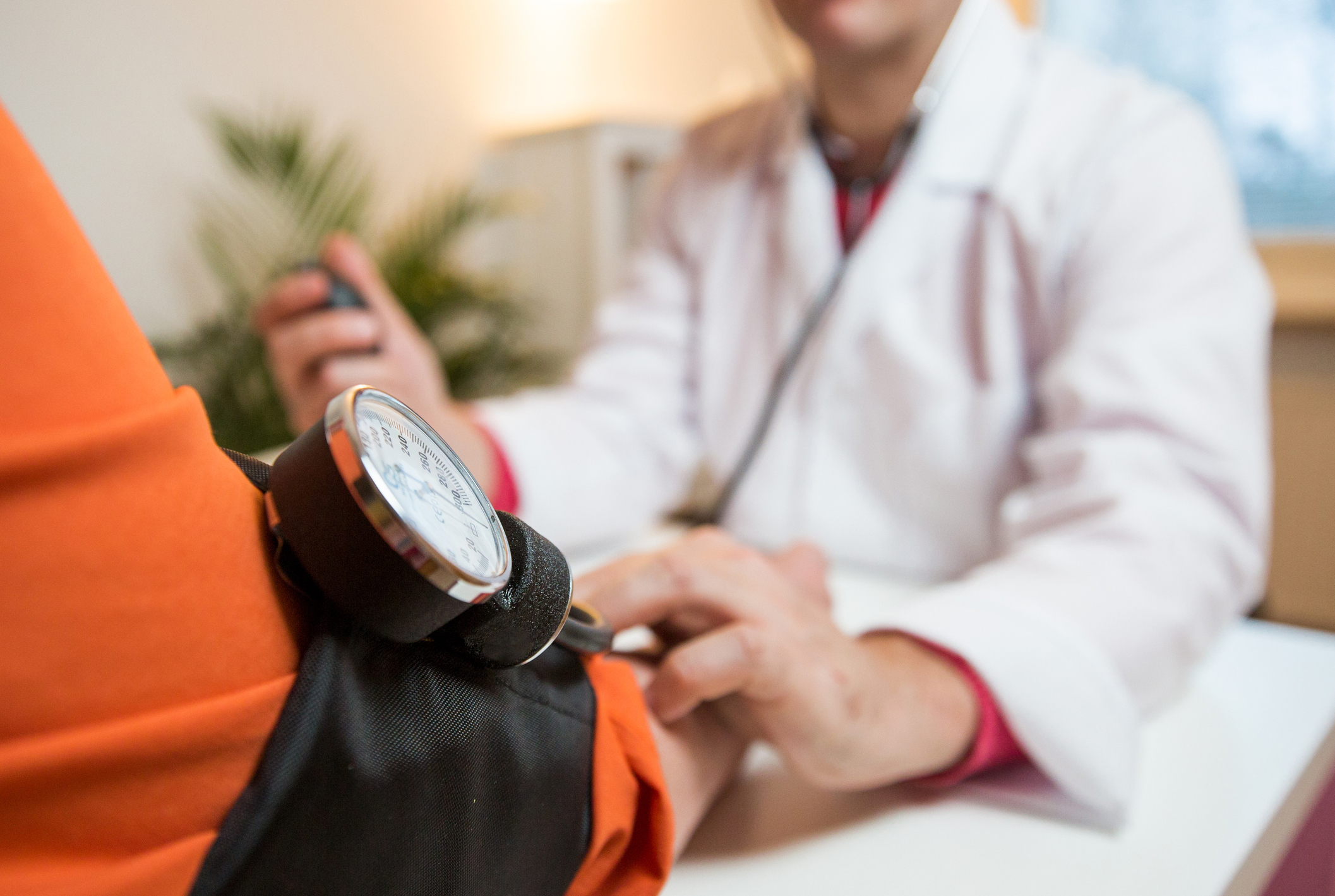 A doctor checks a patient's blood pressure.