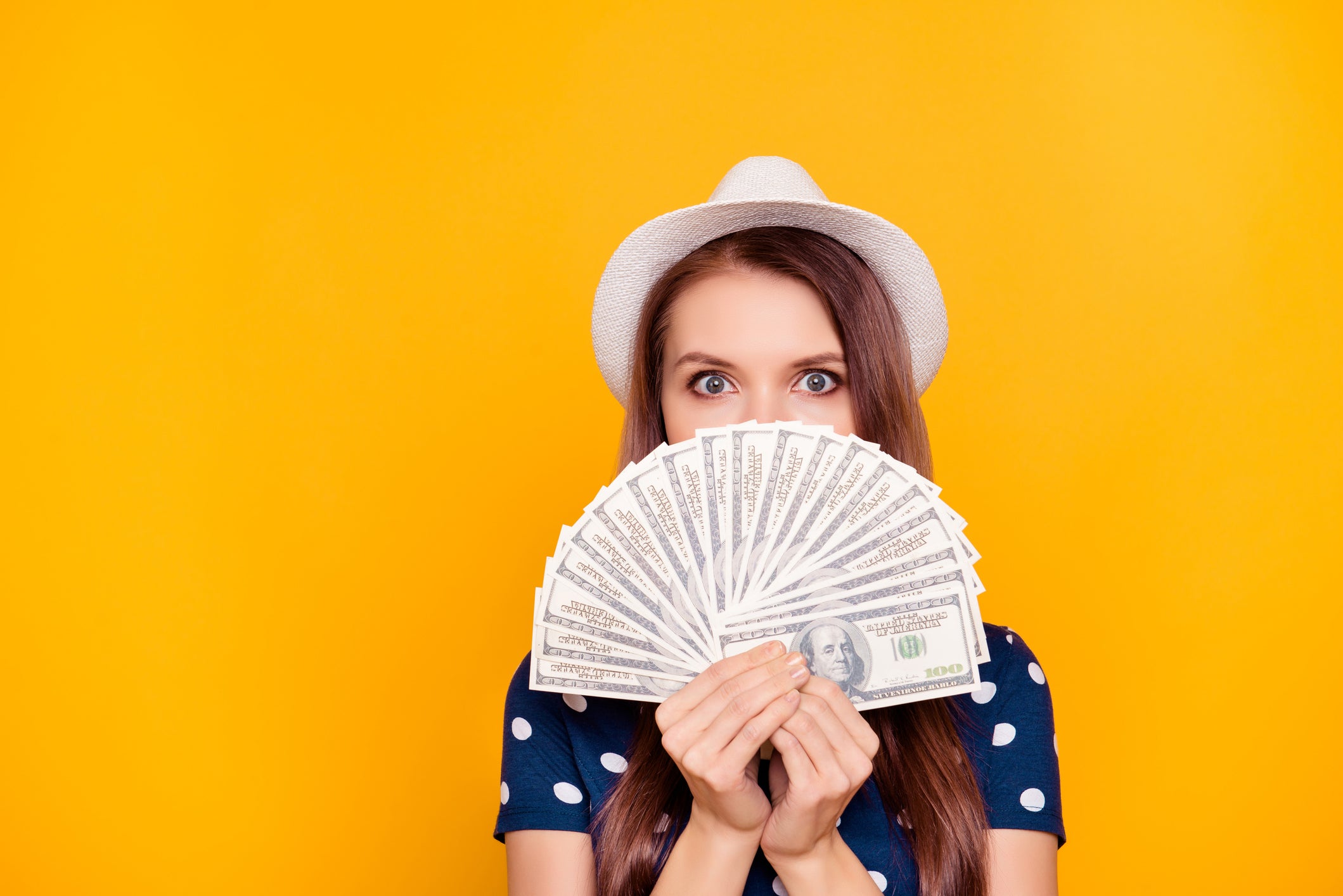 A woman holding up a fan of cash.