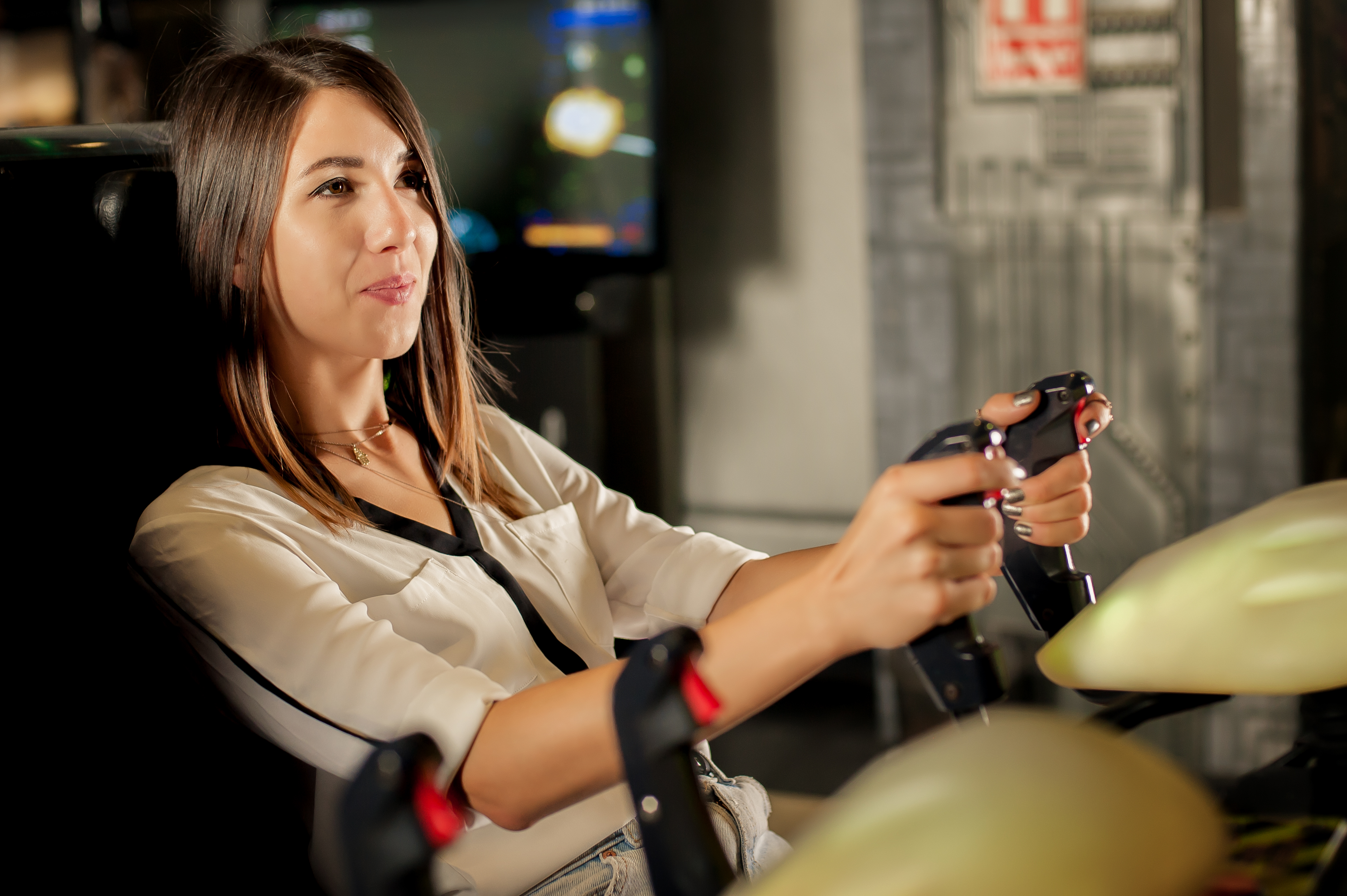 A woman plays an arcade game.