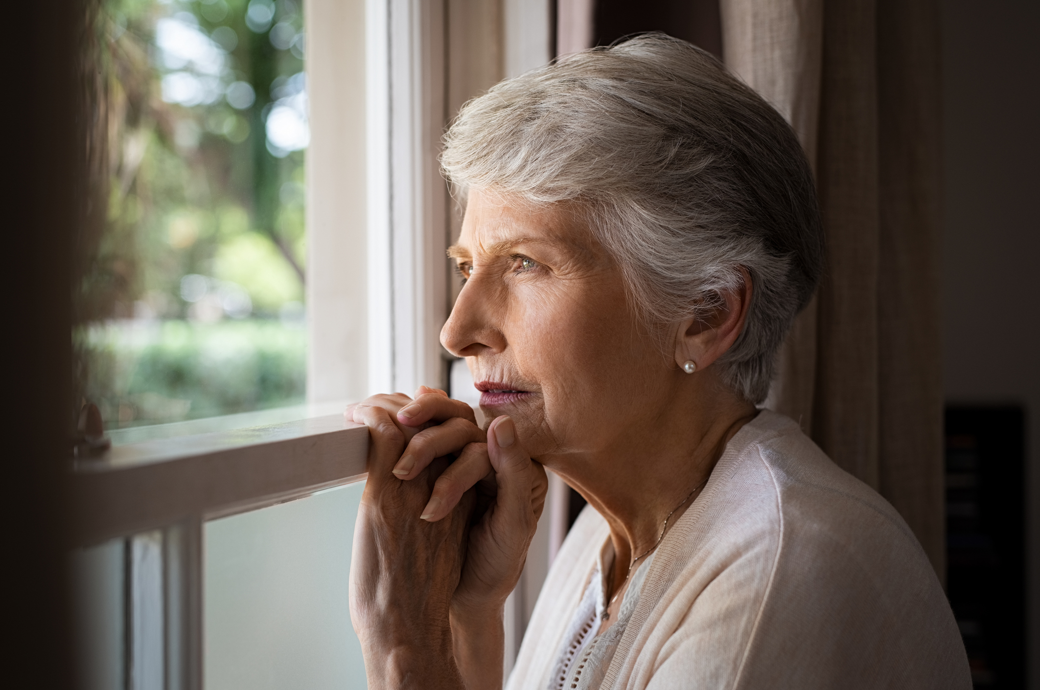 Older woman looking out window