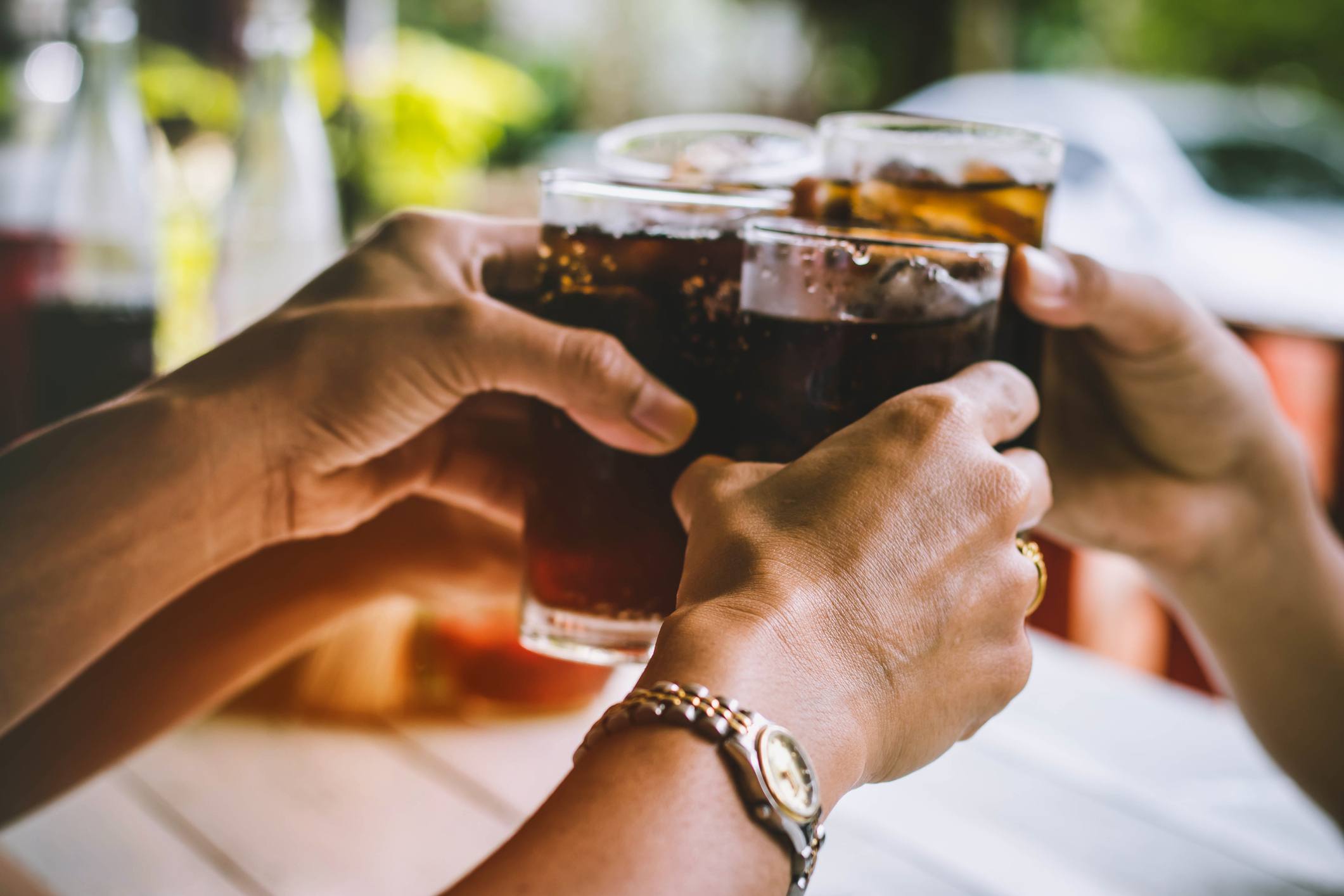 People toasting glasses of Coca-Cola.