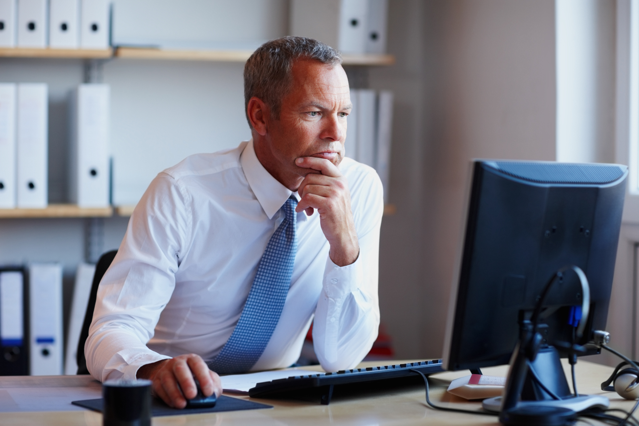 Older man with serious expression at computer