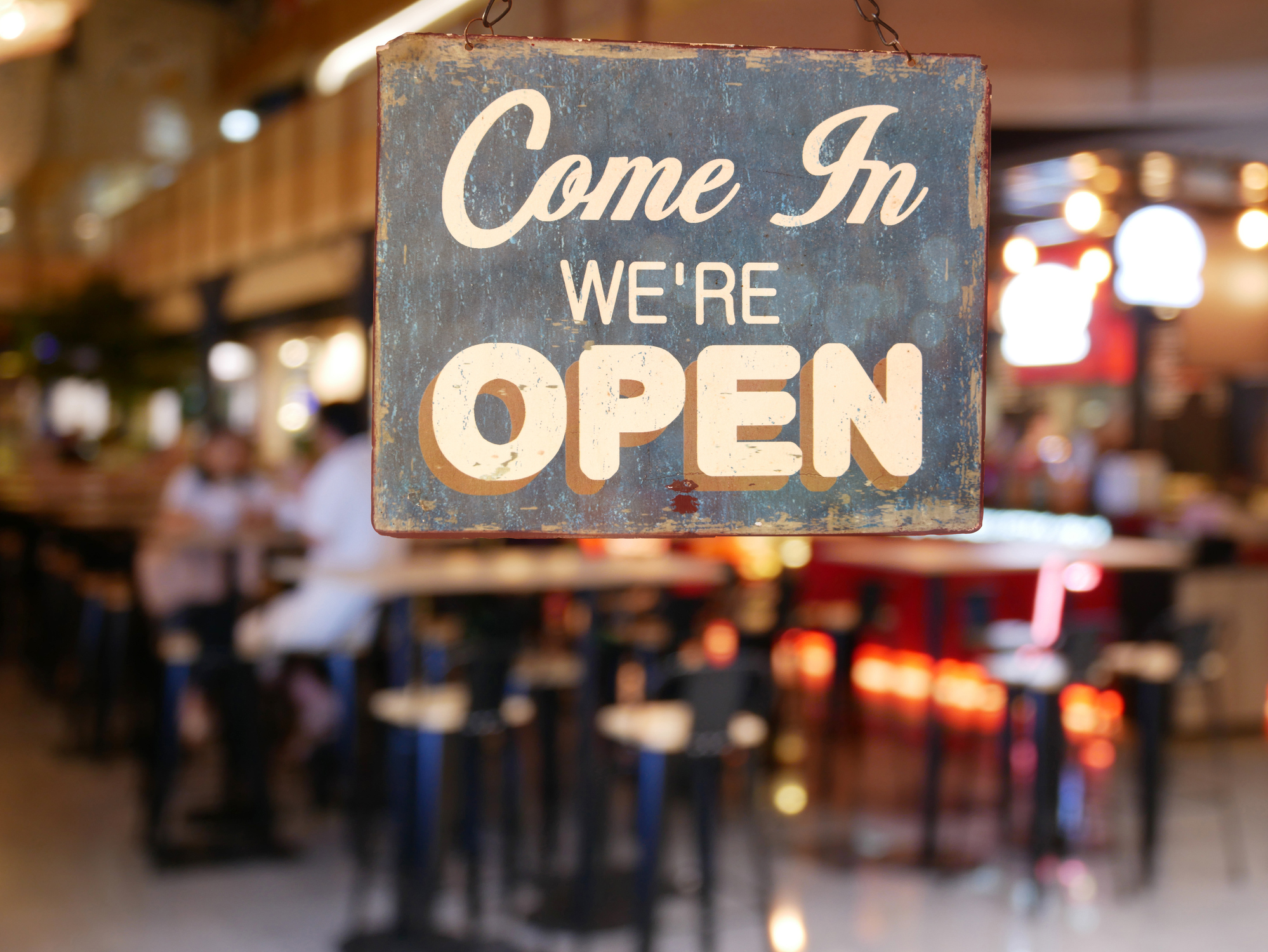 Photo of a restaurant door with a sign reading Come In We're Open.