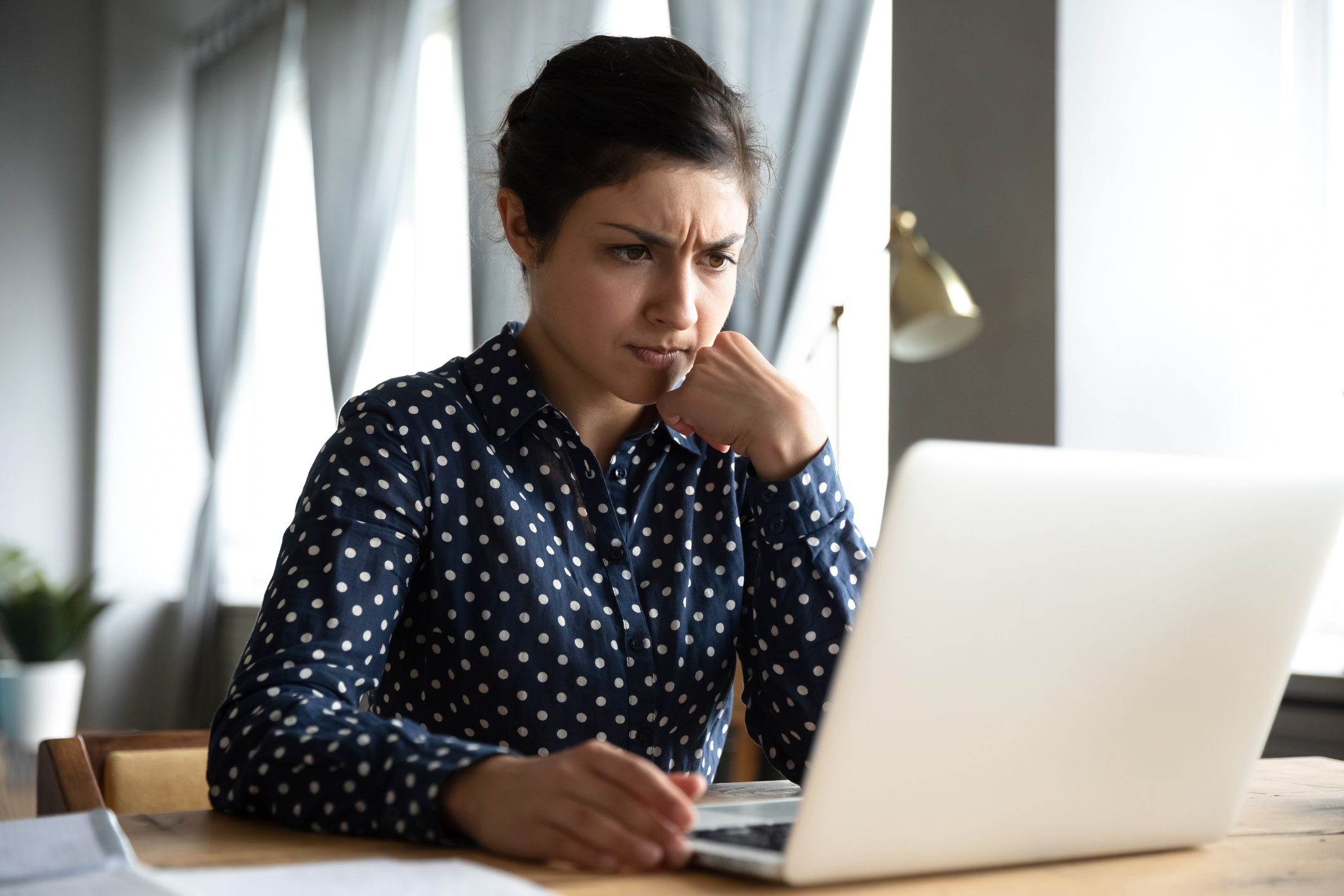 Woman with serious expression at laptop