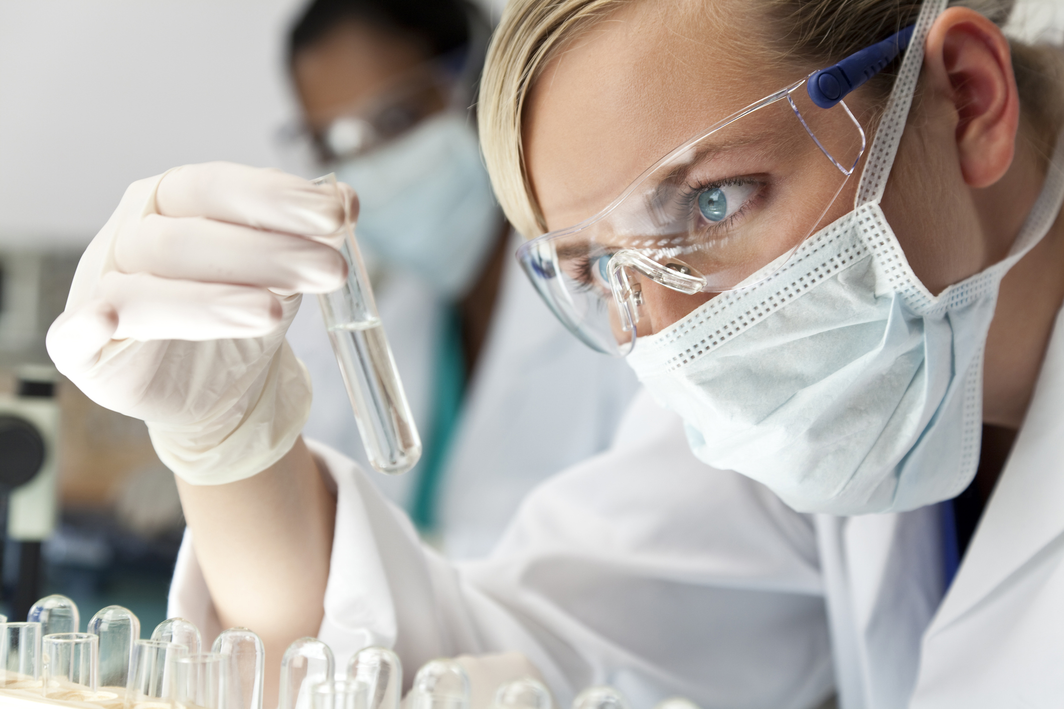 Woman scientist in lab holding up test tube