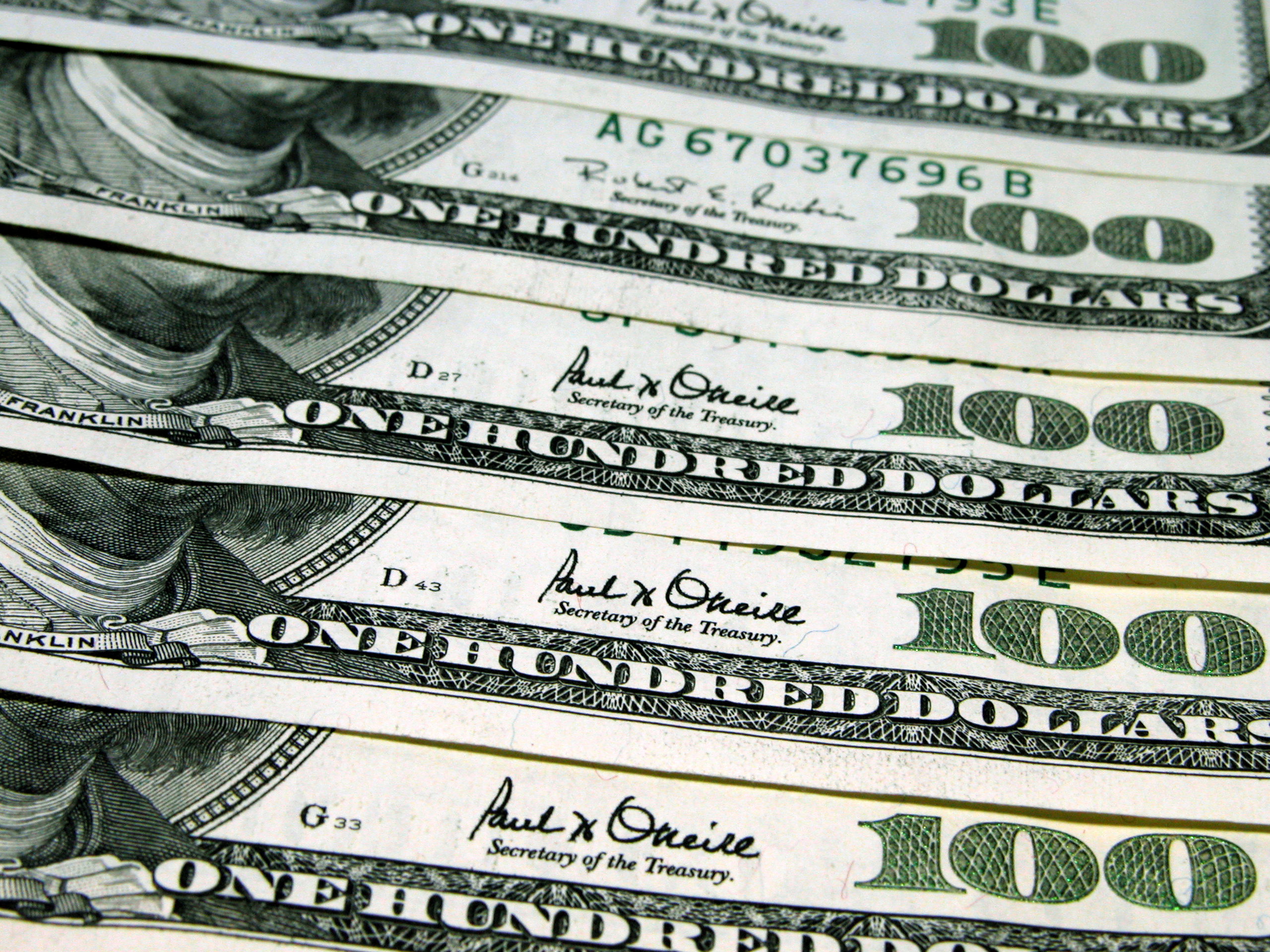 Five one hundred dollar bills neatly lined up.