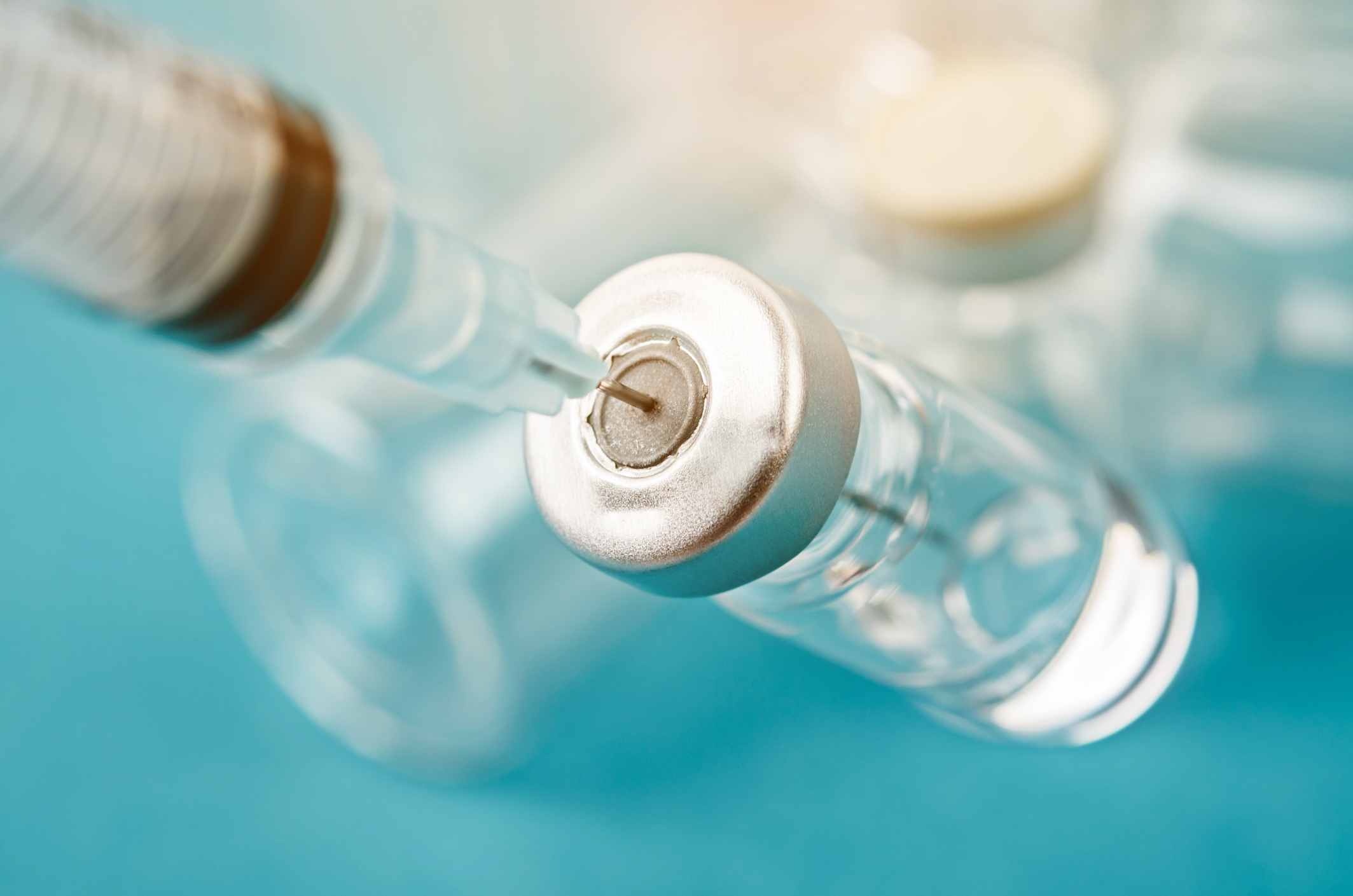 Syringe drawing medicine from a vial