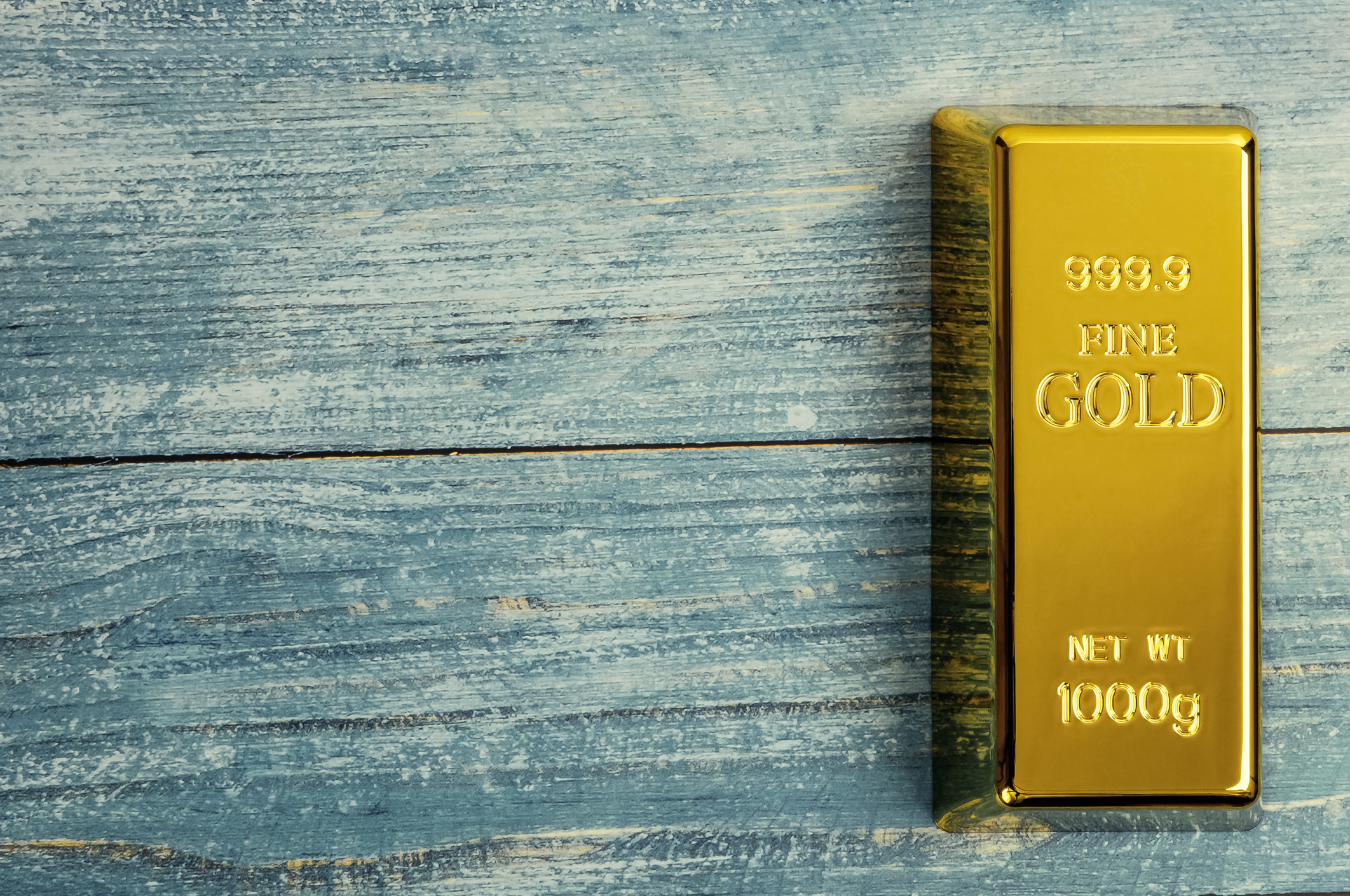 A gold bar on a blue wooden table.