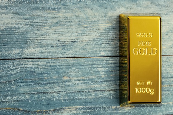 A gold bar on a blue wooden table.