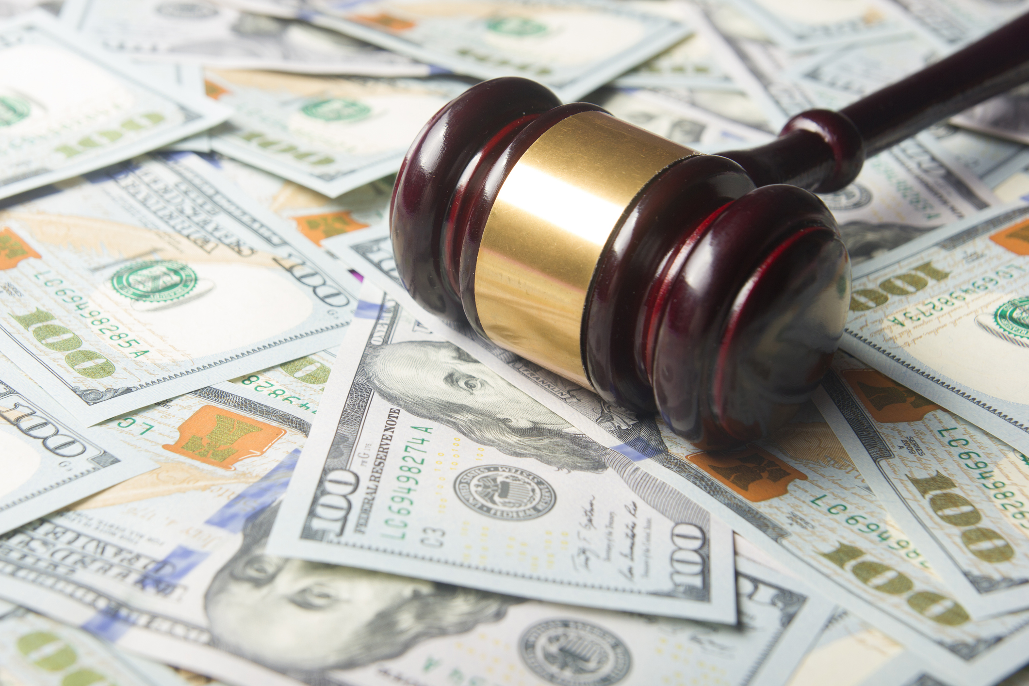 Gavel laying on top of paper currency.