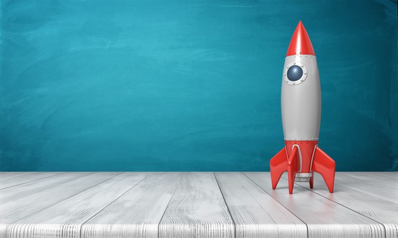 A model of a retro rocket on a wooden desk.