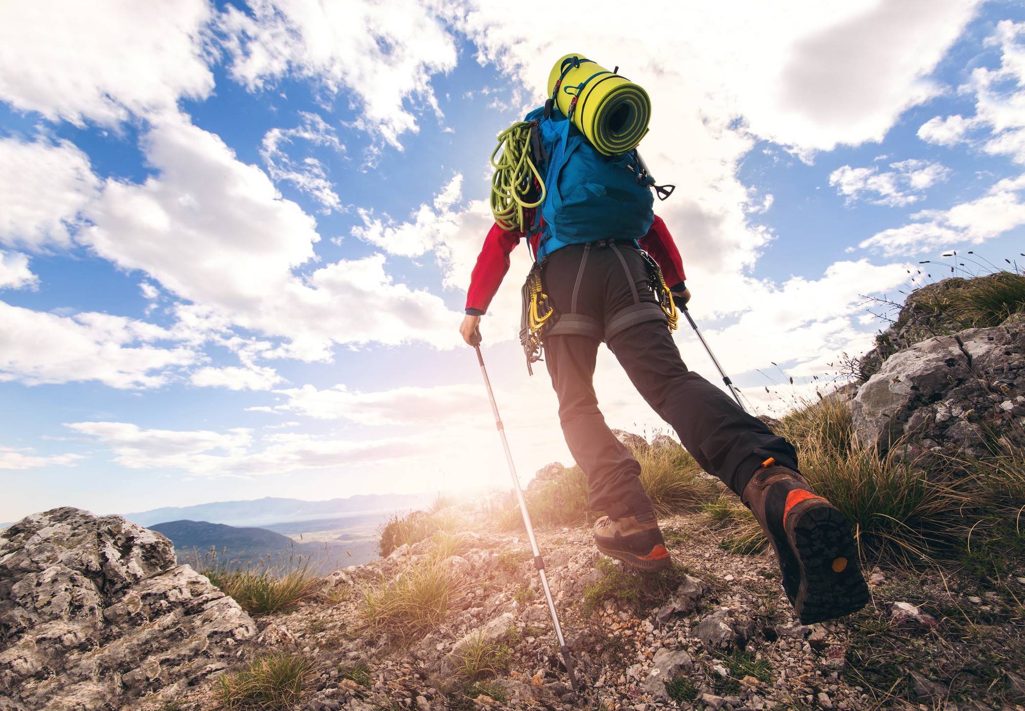 A backpacker with lots of gear hikes a mountain.