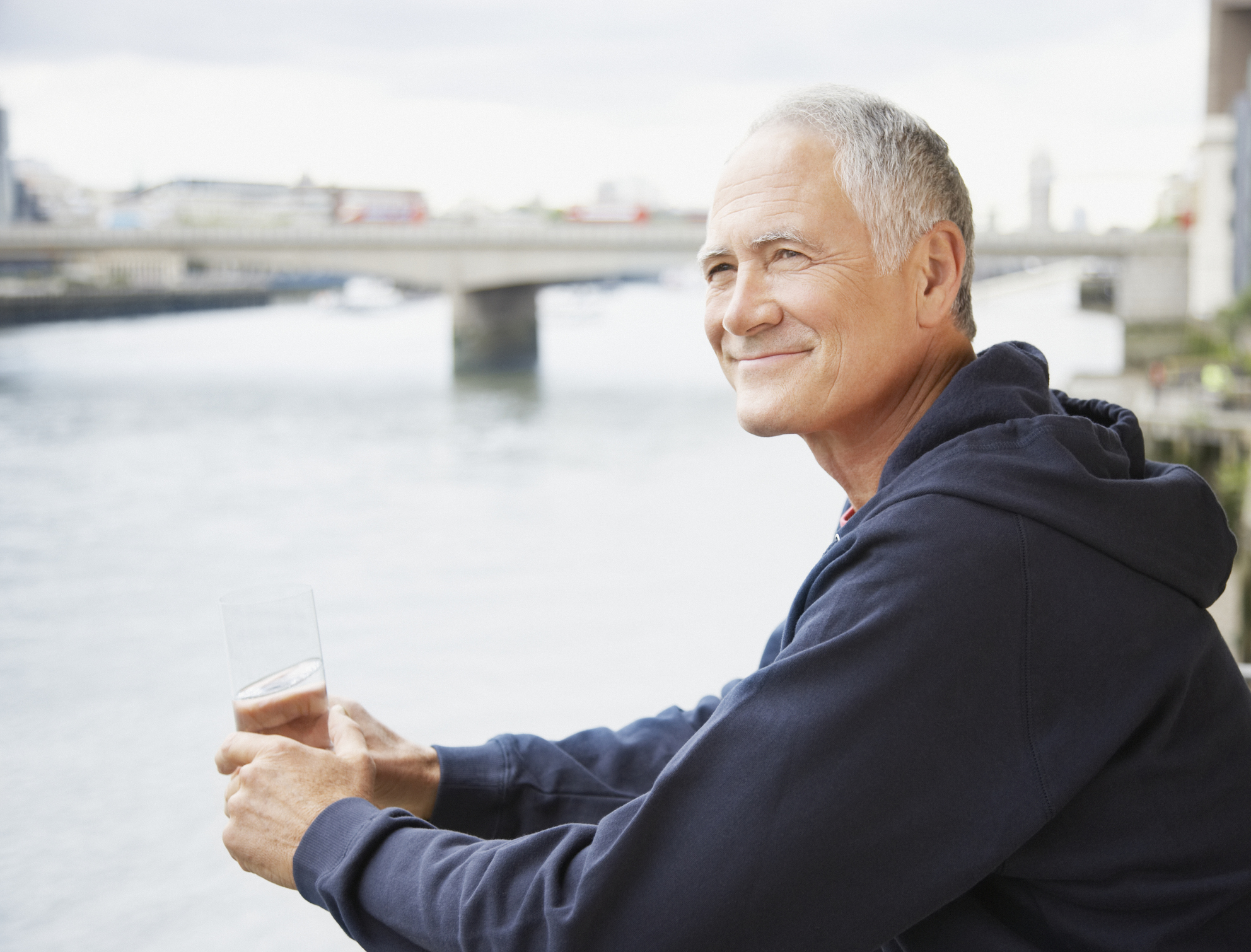 Older man by the water holding glass