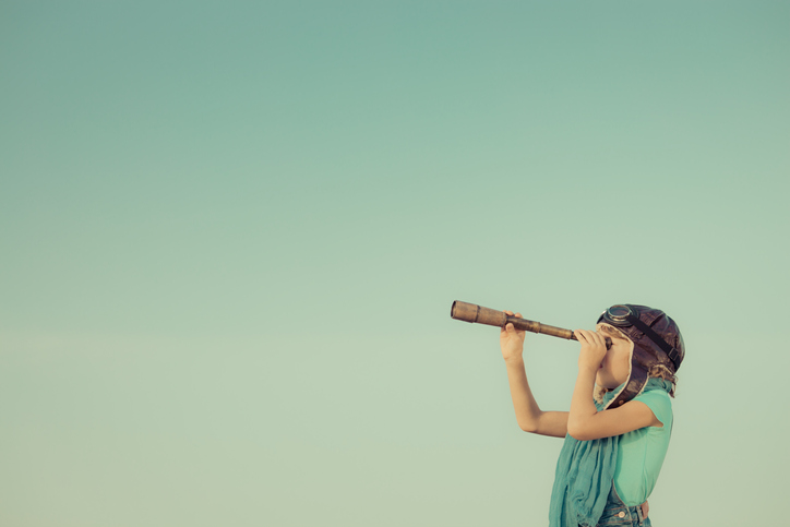 A kid looking through a telescope spyglass