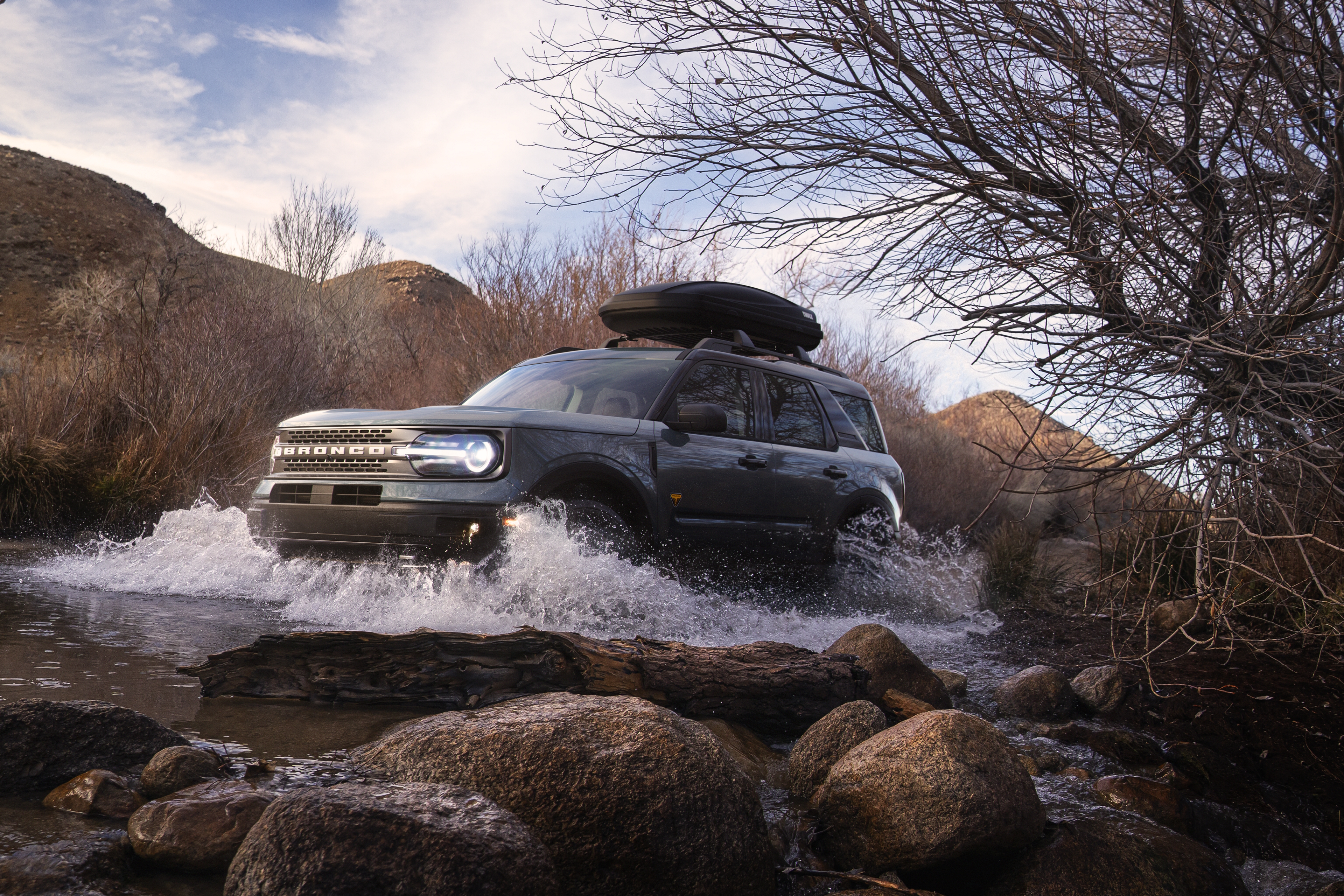 A Ford Bronco Sport fording a small stream