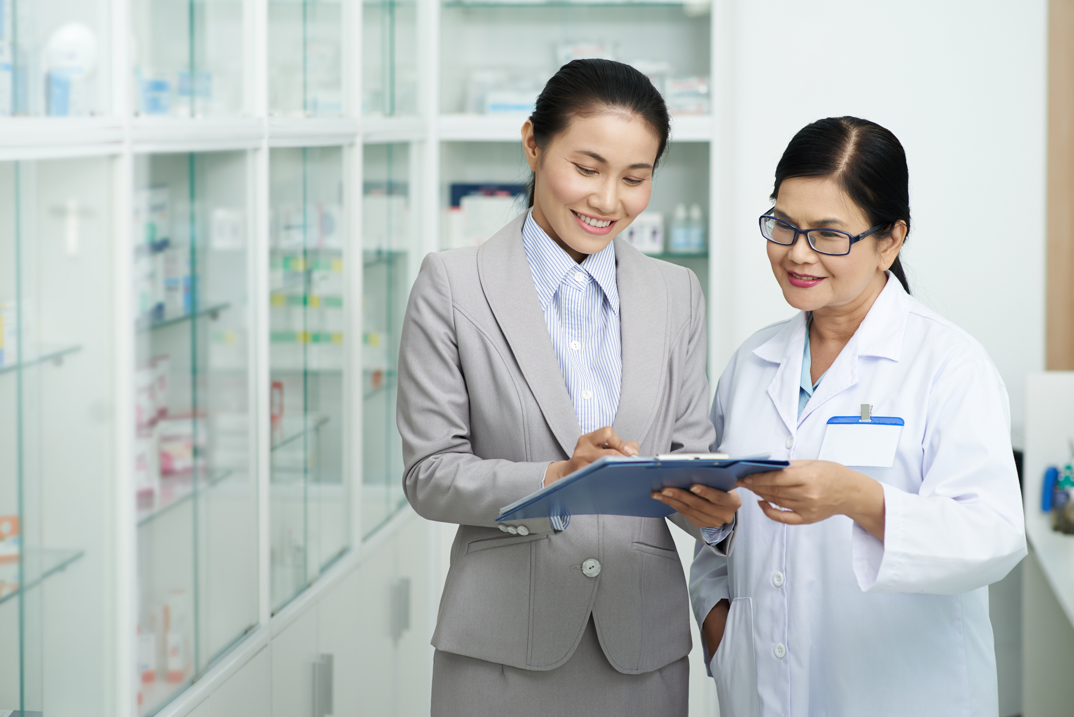 Two scientists with clipboard at a pharmacy.