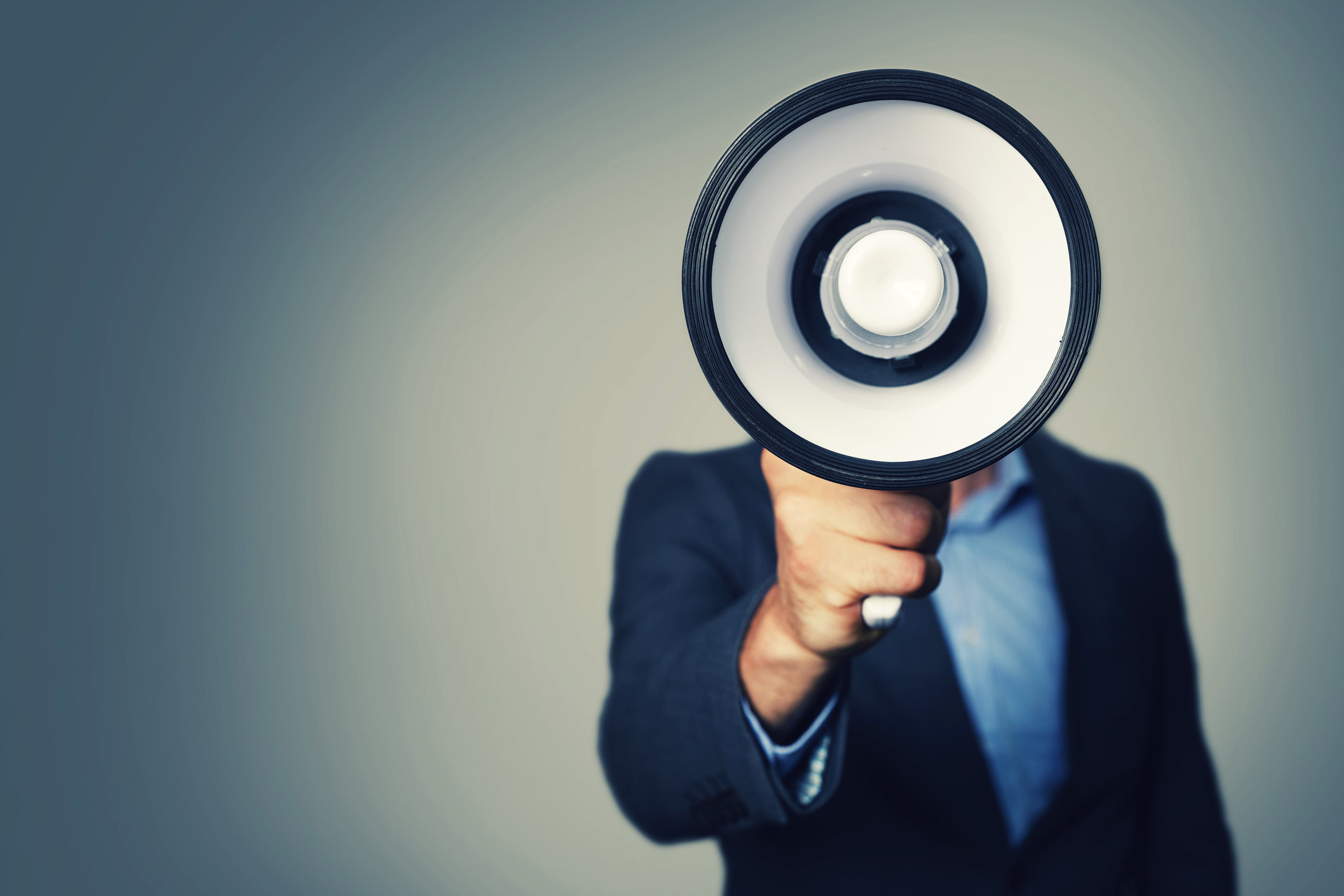 A business person speaks through a megaphone.