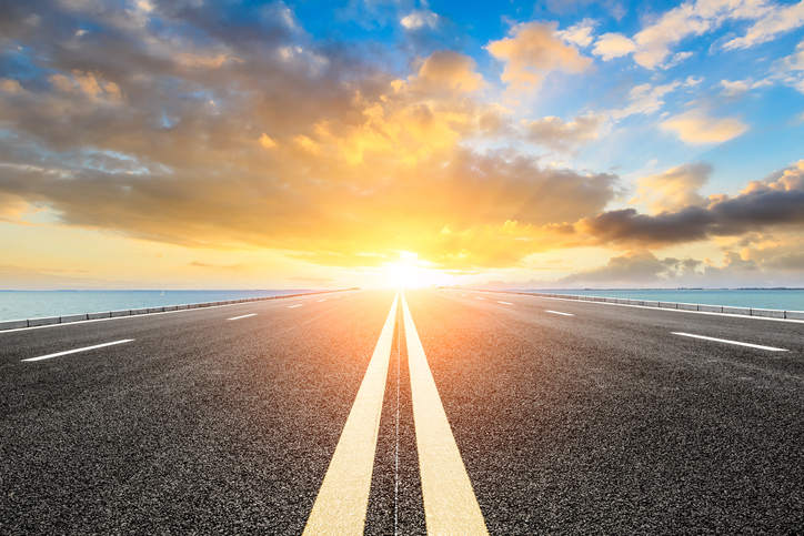 View down a roadway into a bright horizon.