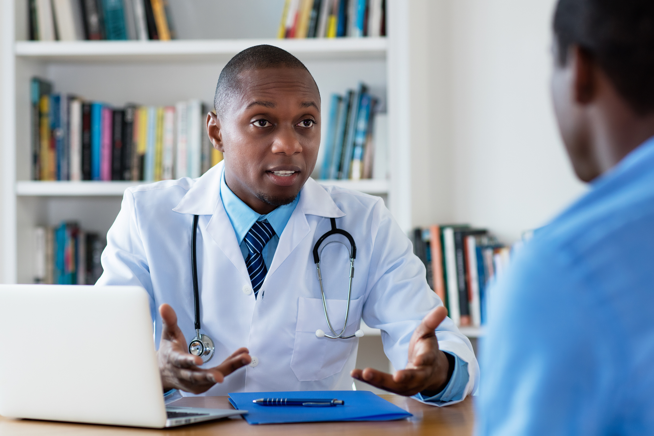 Doctor behind a desk talking to a patient