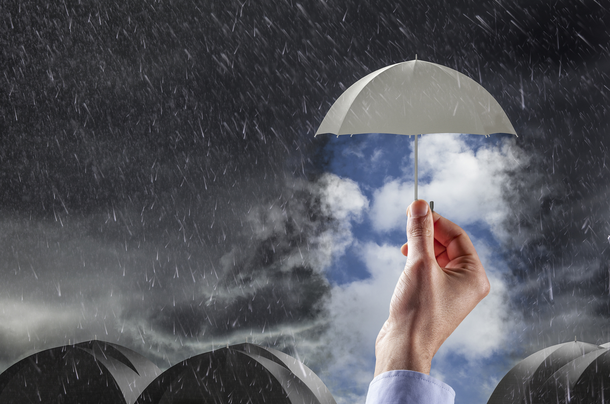 An umbrella is lifted high to reveal a clear, blue sky surrounded by rain and lower umbrellas.