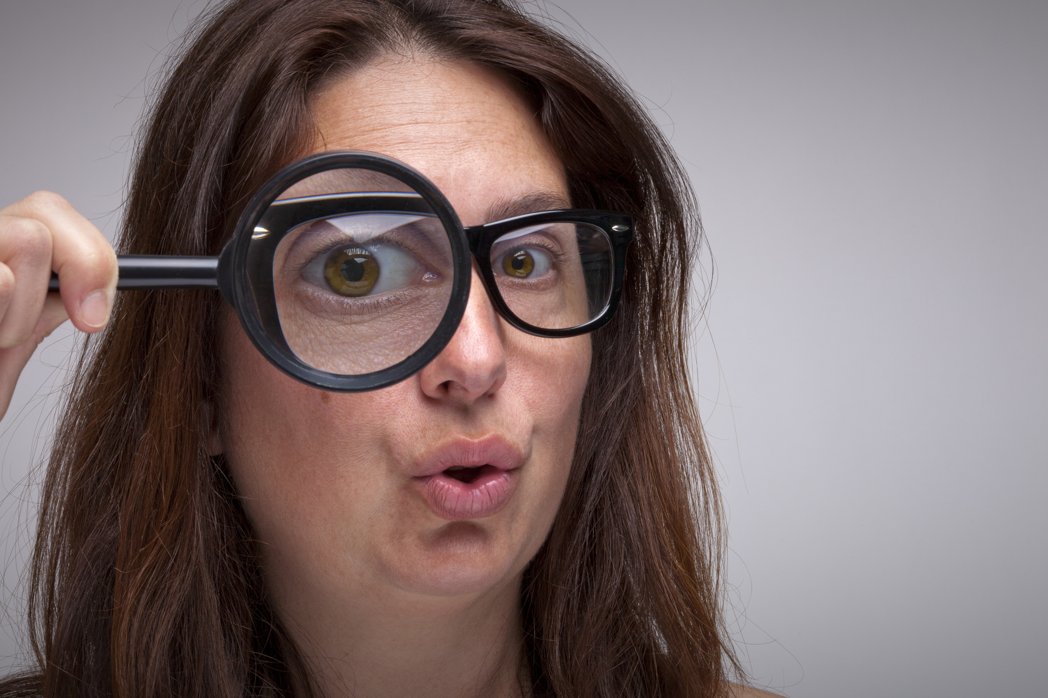 Woman looking through a magnifying glass