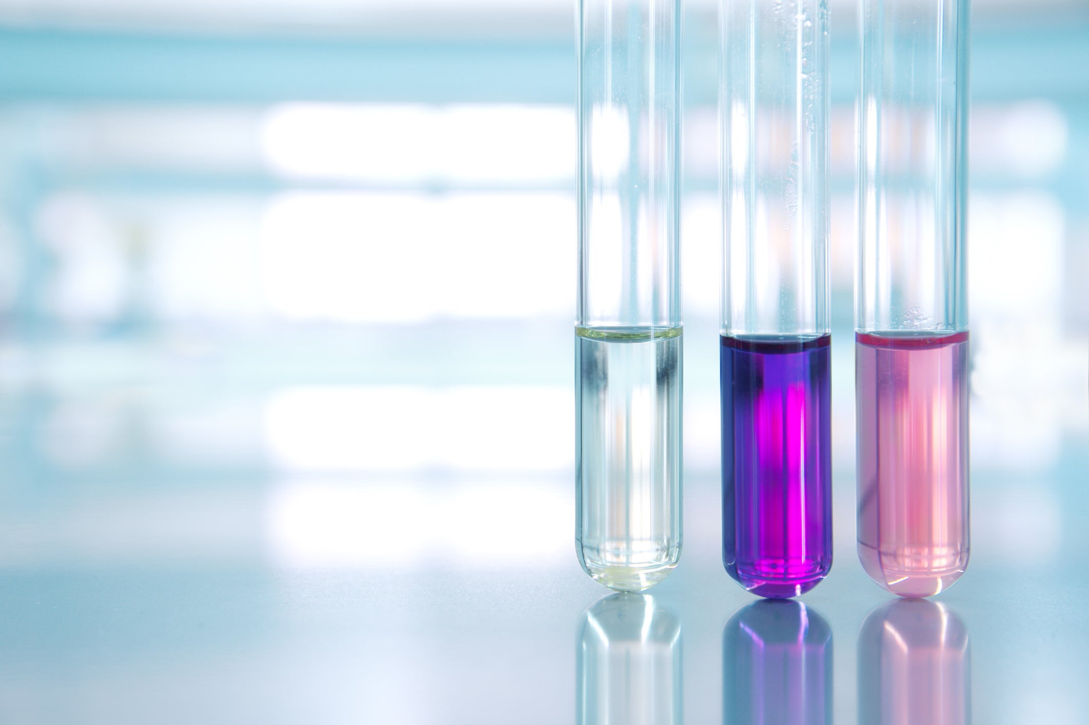 Three test tubes containing different-colored liquids
