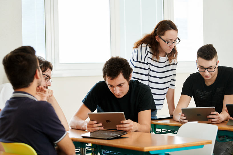 College students using iPads in a classroom.