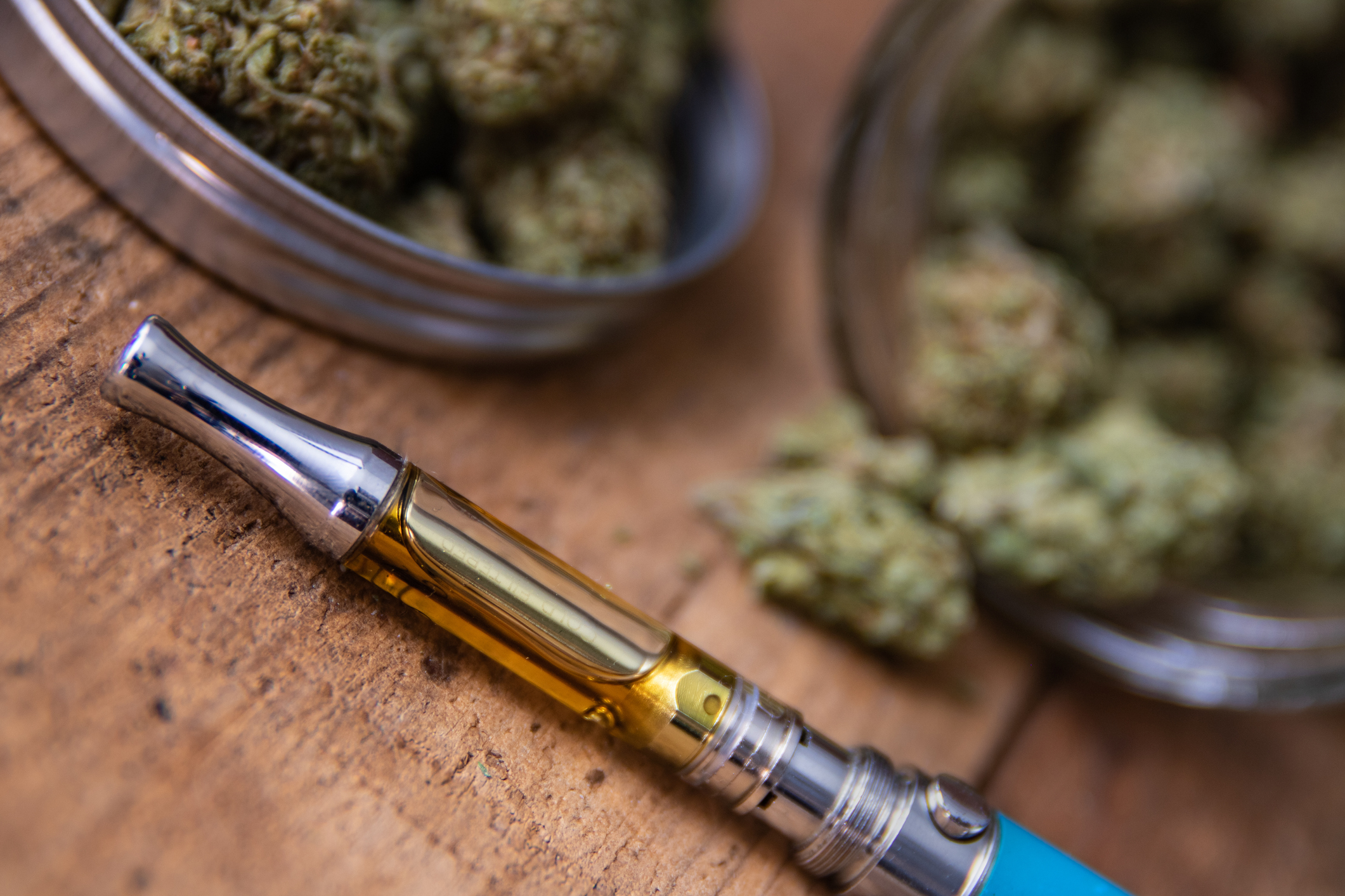 Cannabis Vaporizer on table surrounded by cannabis.