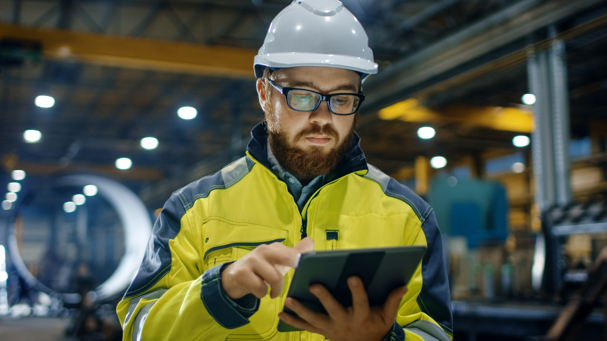 Man in hard hat looking at tablet