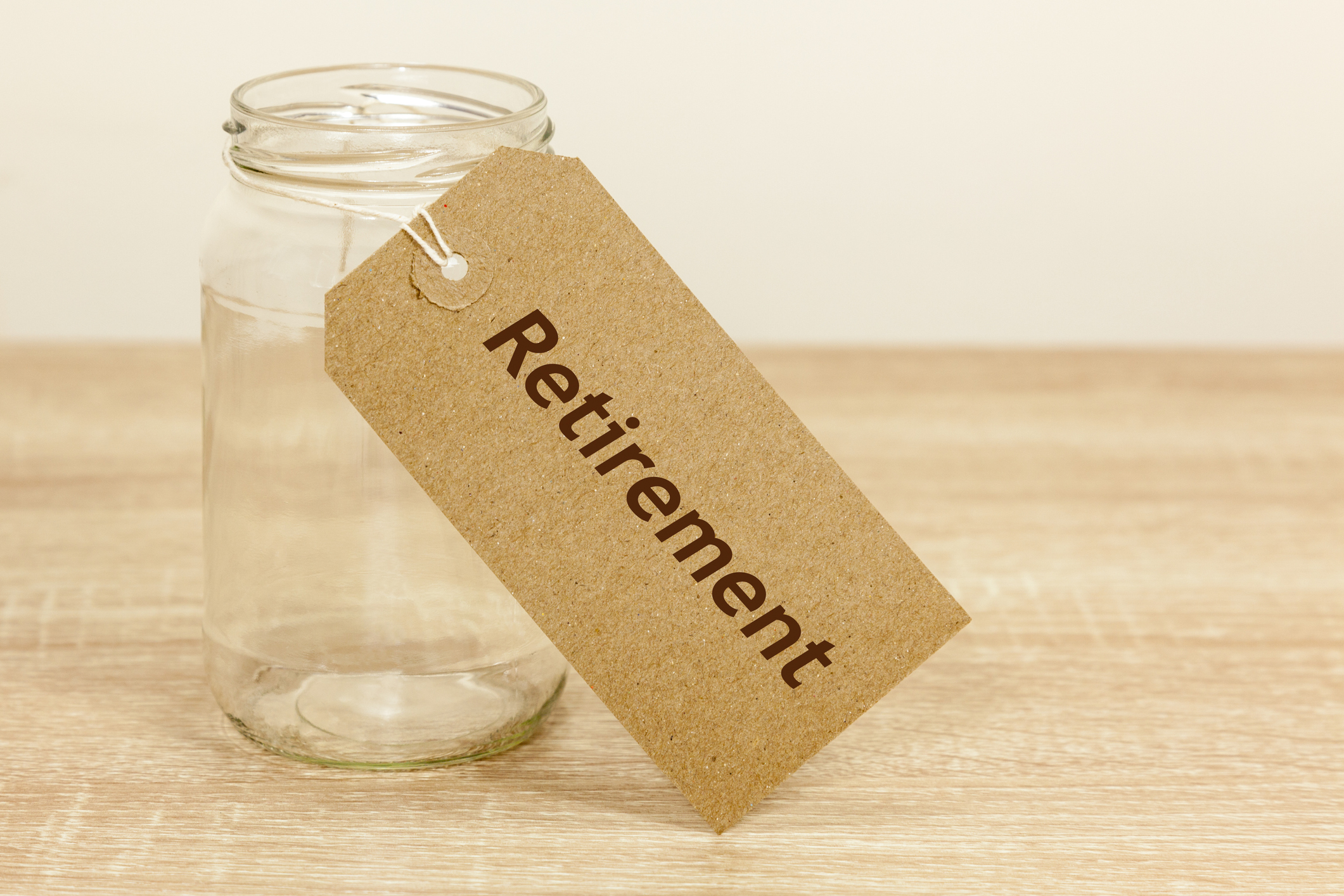 Empty glass jar with tag attached reading retirement