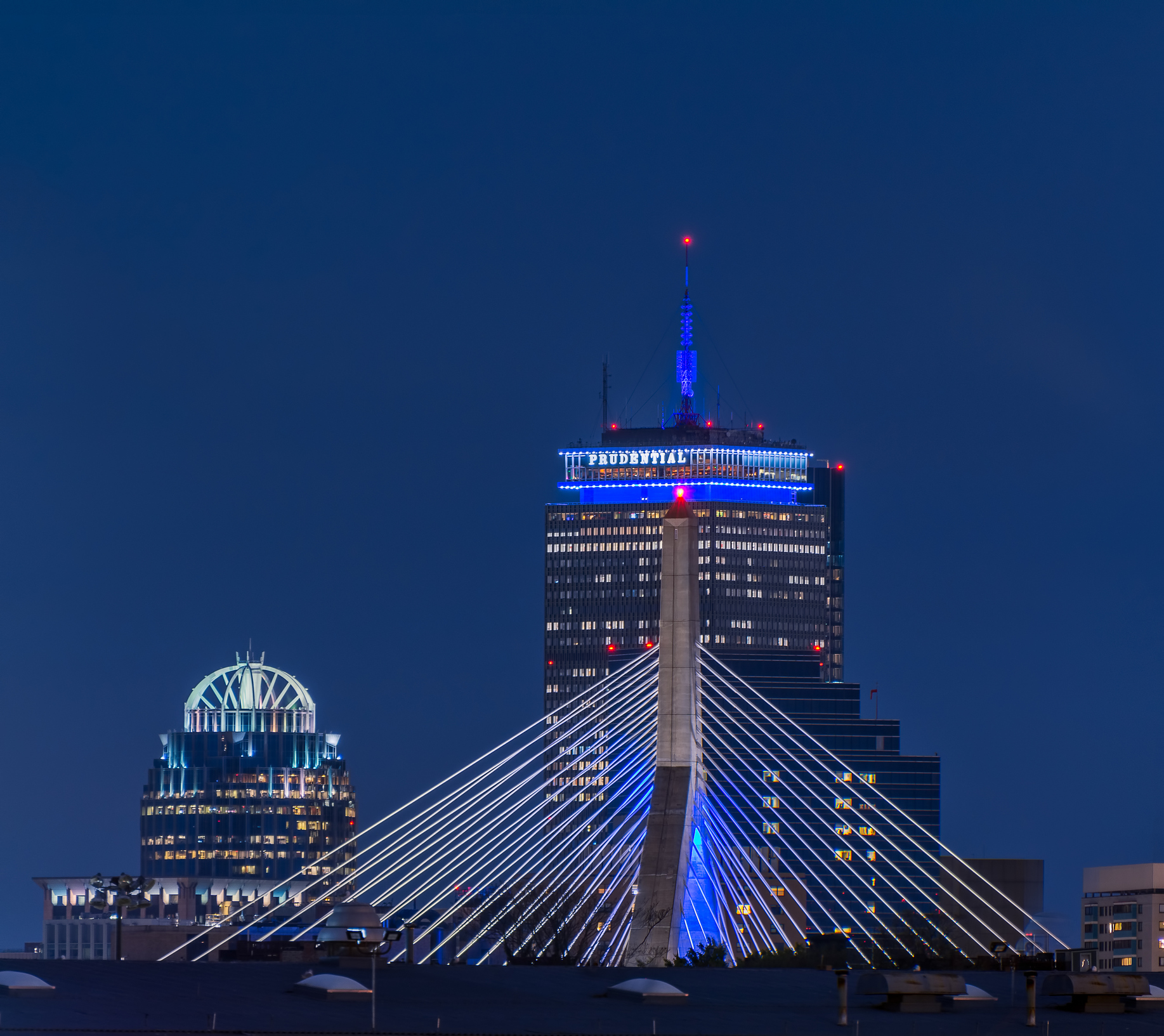 The Prudential Building in Boston at night, with the Zakim Bridge in the foreground.
