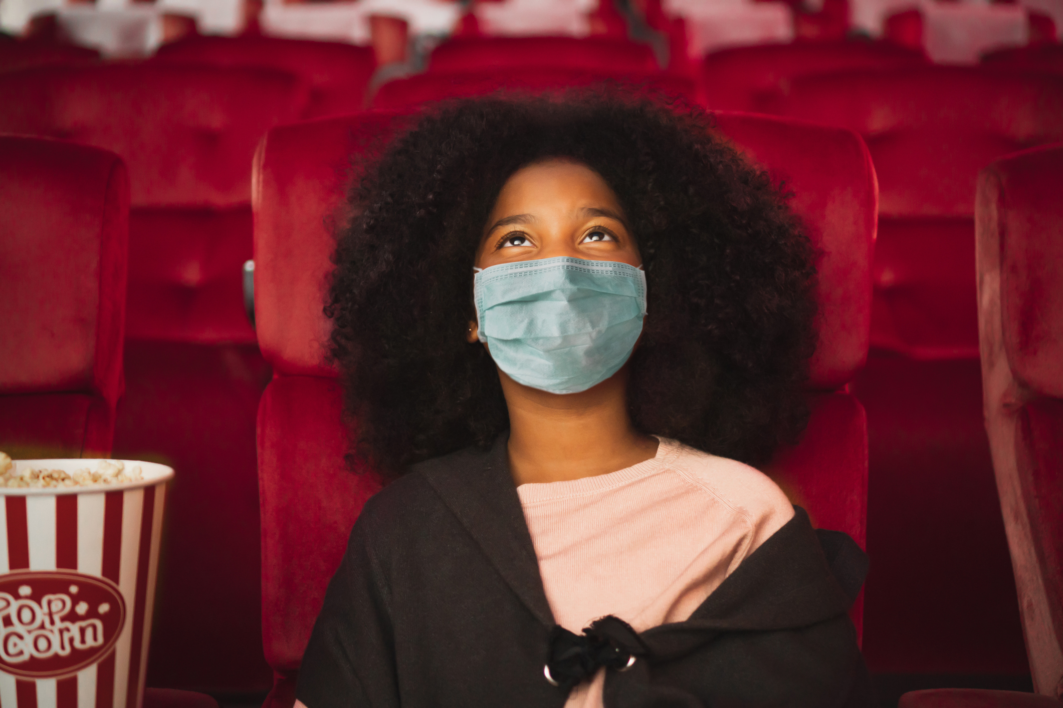 Child wearing mask in empty theater